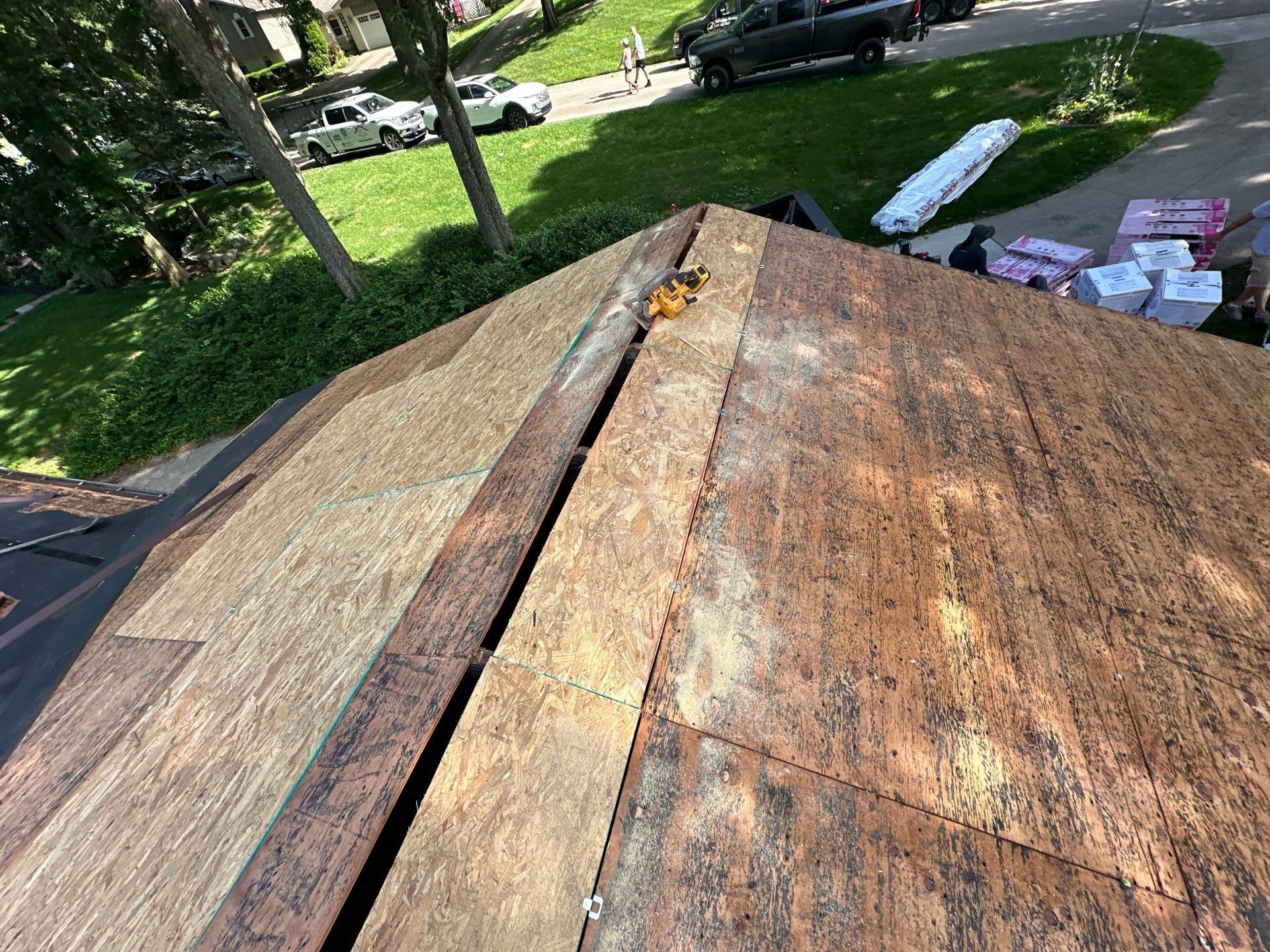The bare roof deck after tear-off, with the new materials staged in the driveway, Beavercreek, Ohio.