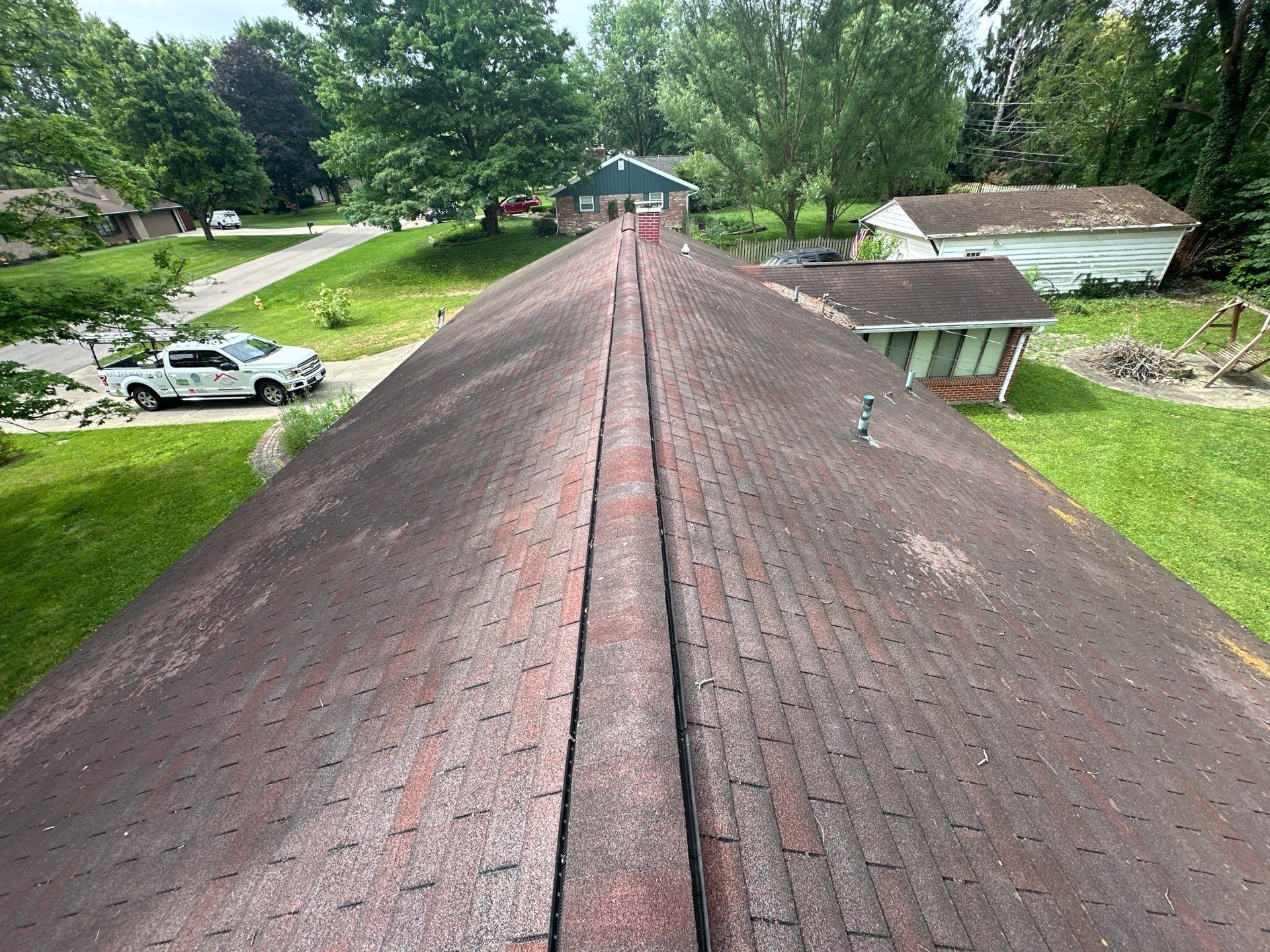 Red-brown roof, work truck and outbuilding