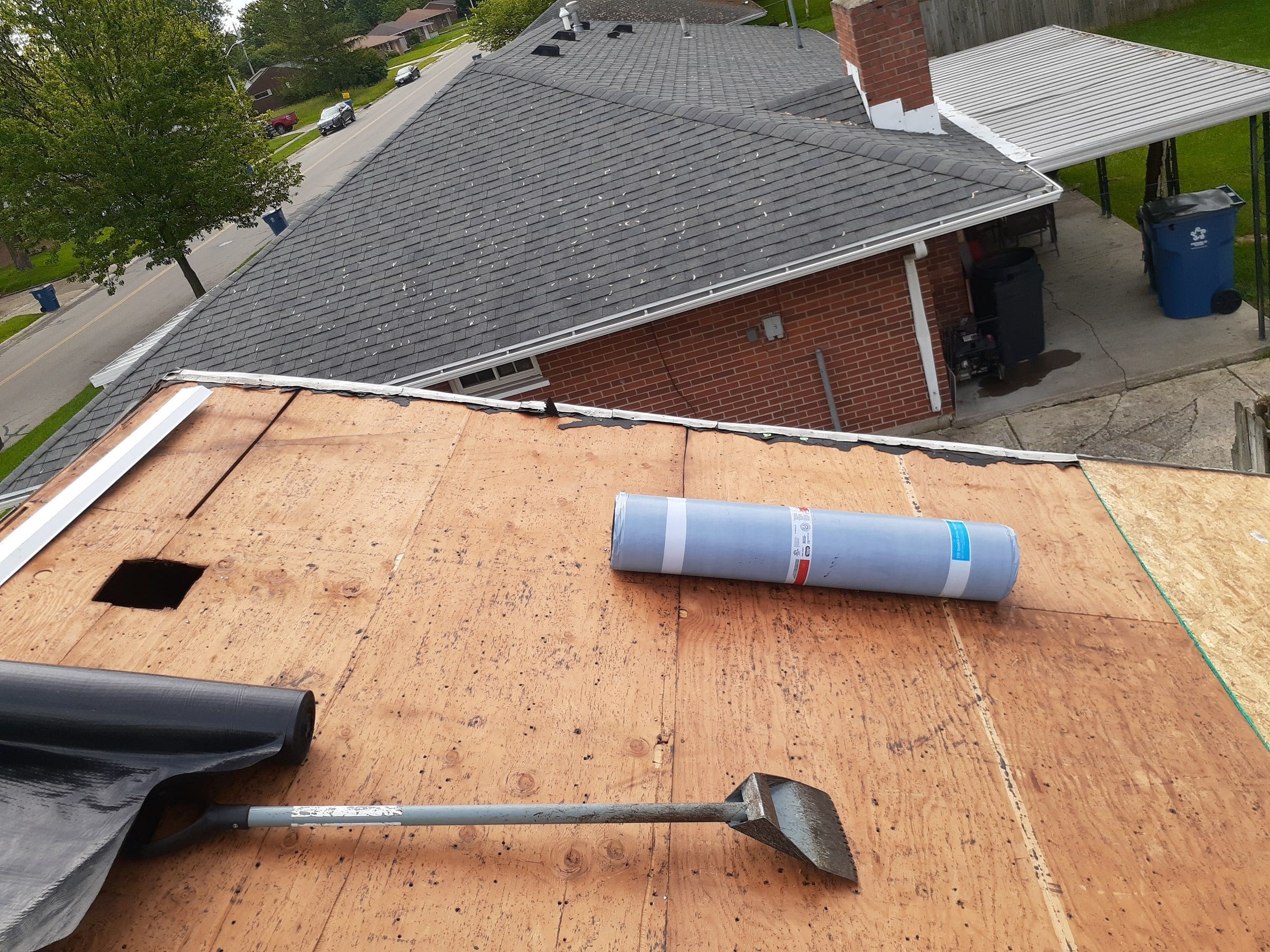 An open vent hole in the deck with underlayment rolls nearby, Huber Heights, Ohio.