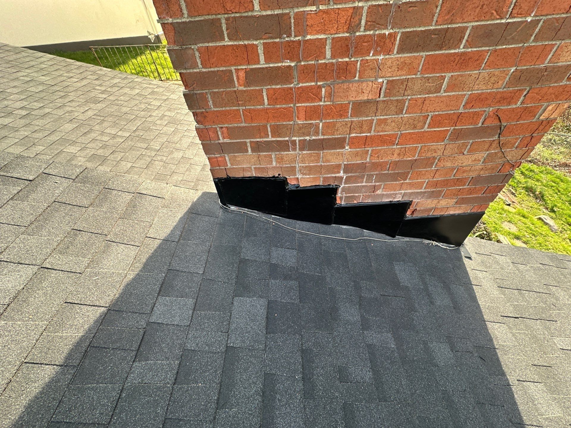Step flashing up the brick chimney