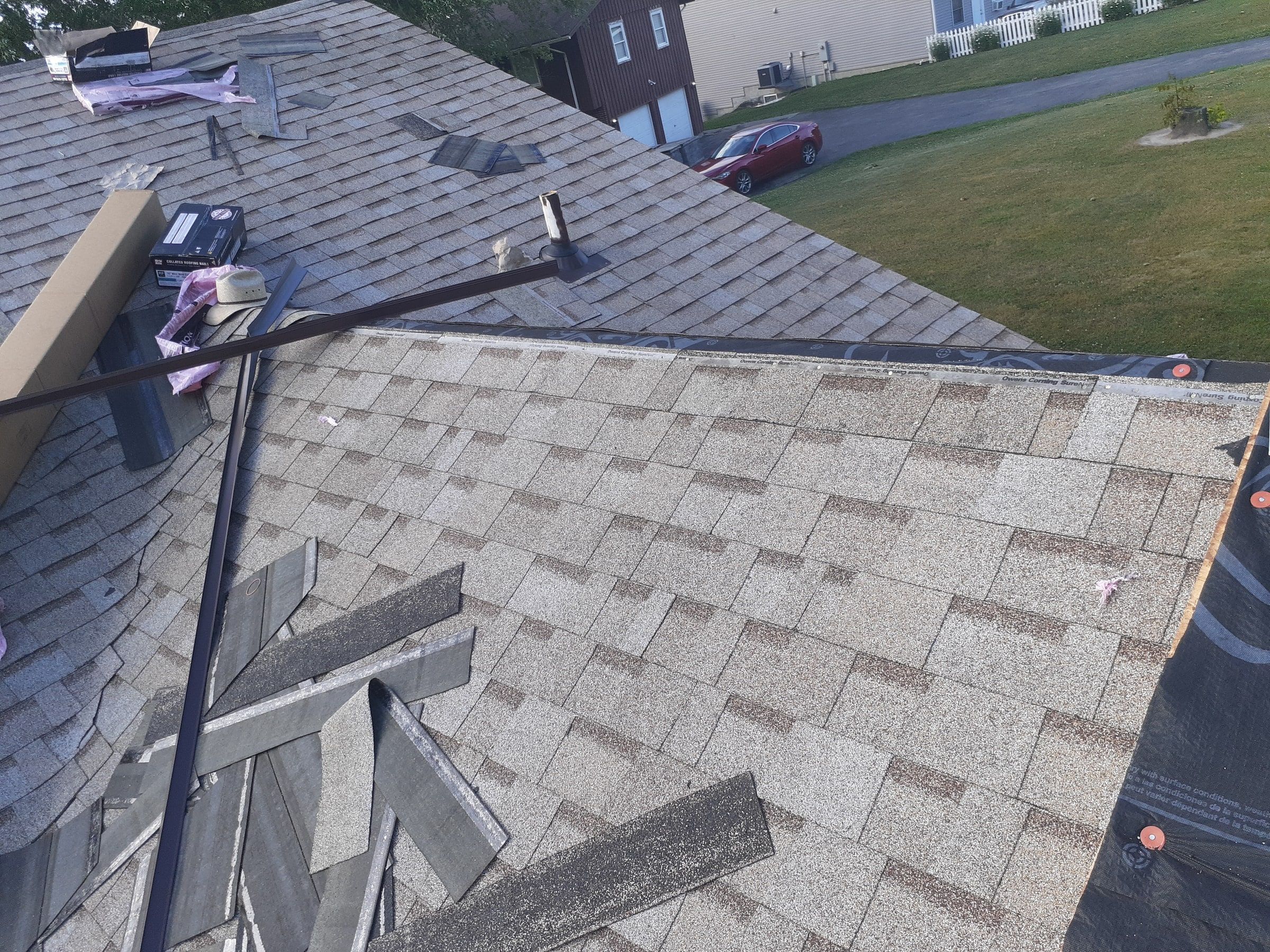 Shingles laid toward the hip with tools and scraps on the roof, Jamestown, Ohio.