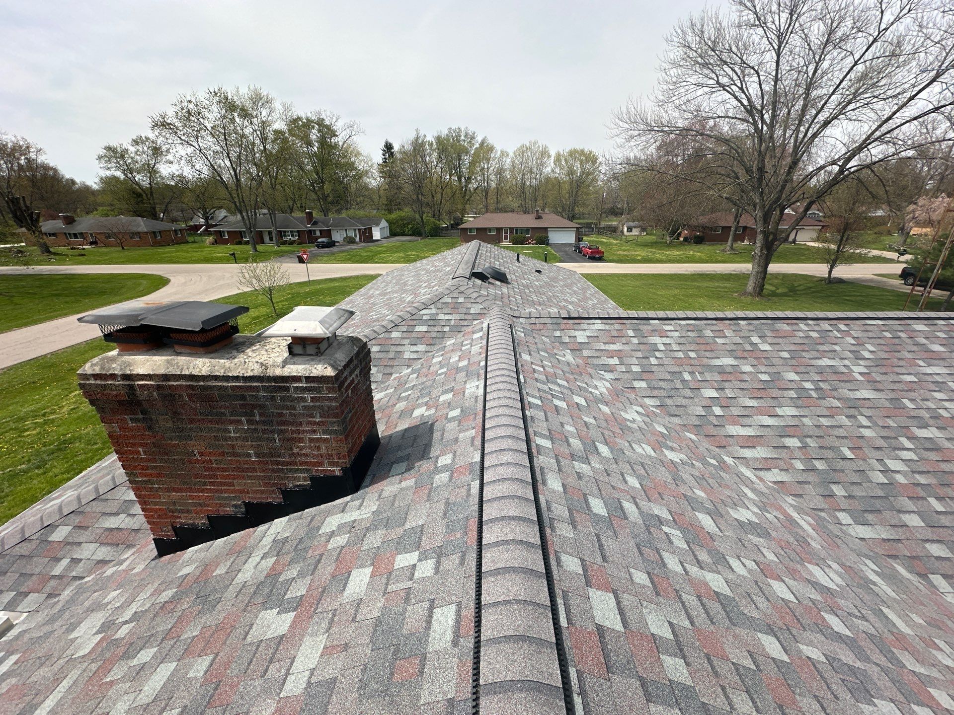 Finished ridge vent running past the chimney on the new roof, Beavercreek, Ohio.