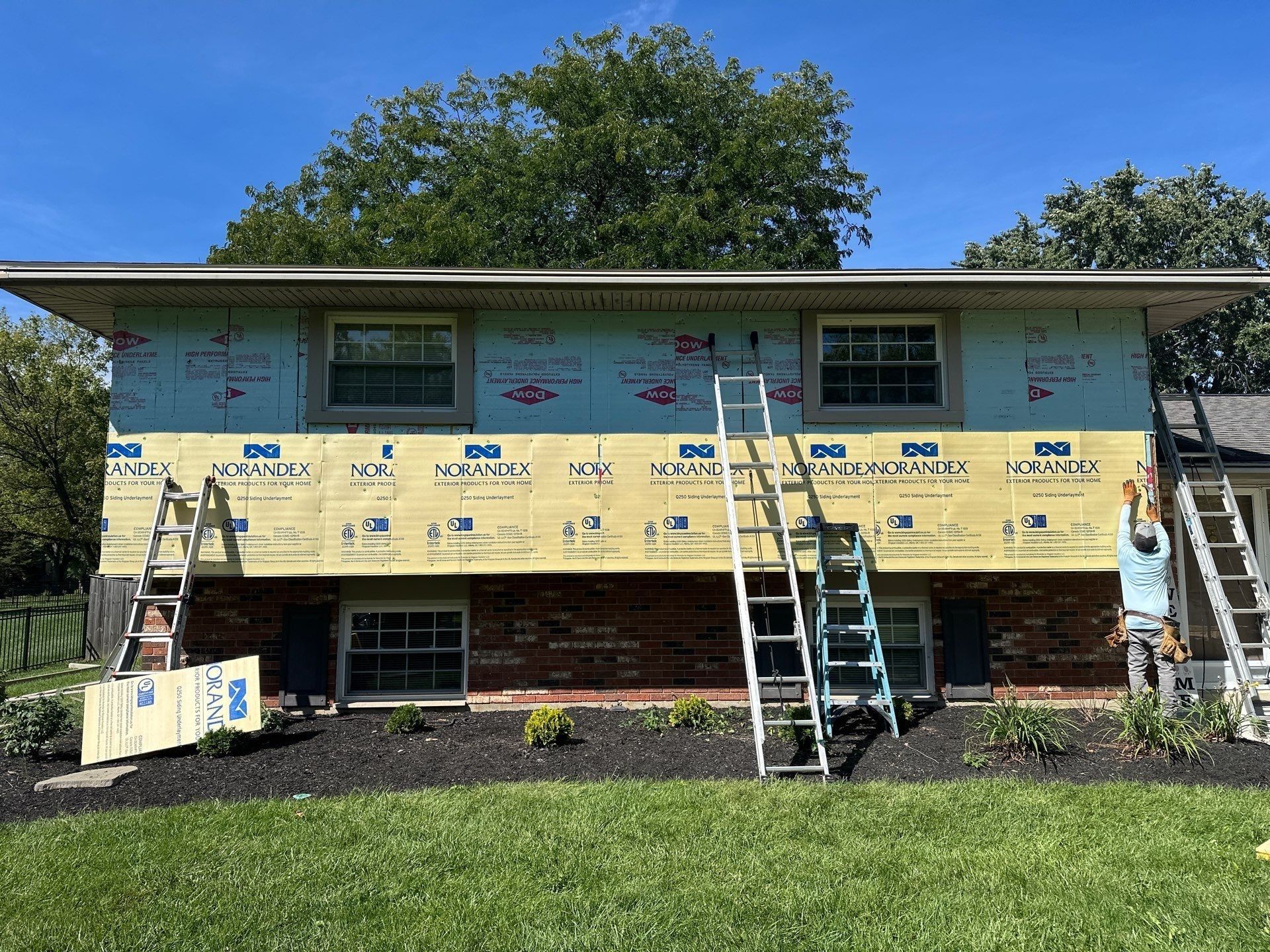 Norandex house wrap across the back wall, with crews on ladders, Beavercreek, Ohio.