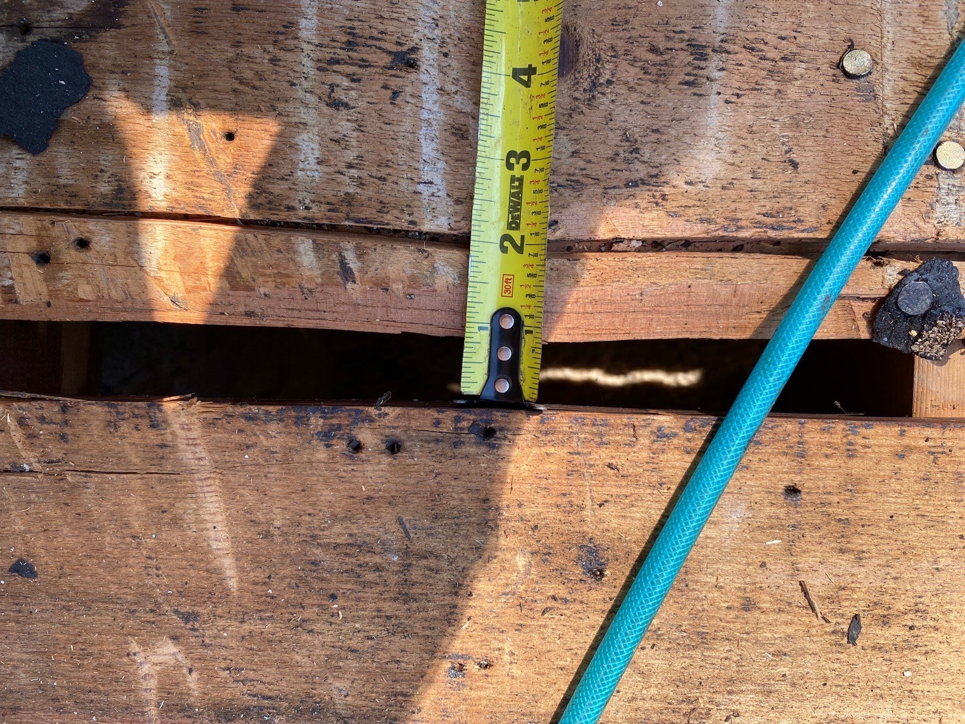 Tape measure over an open gap in the plank deck with the attic below, Beavercreek, Ohio.