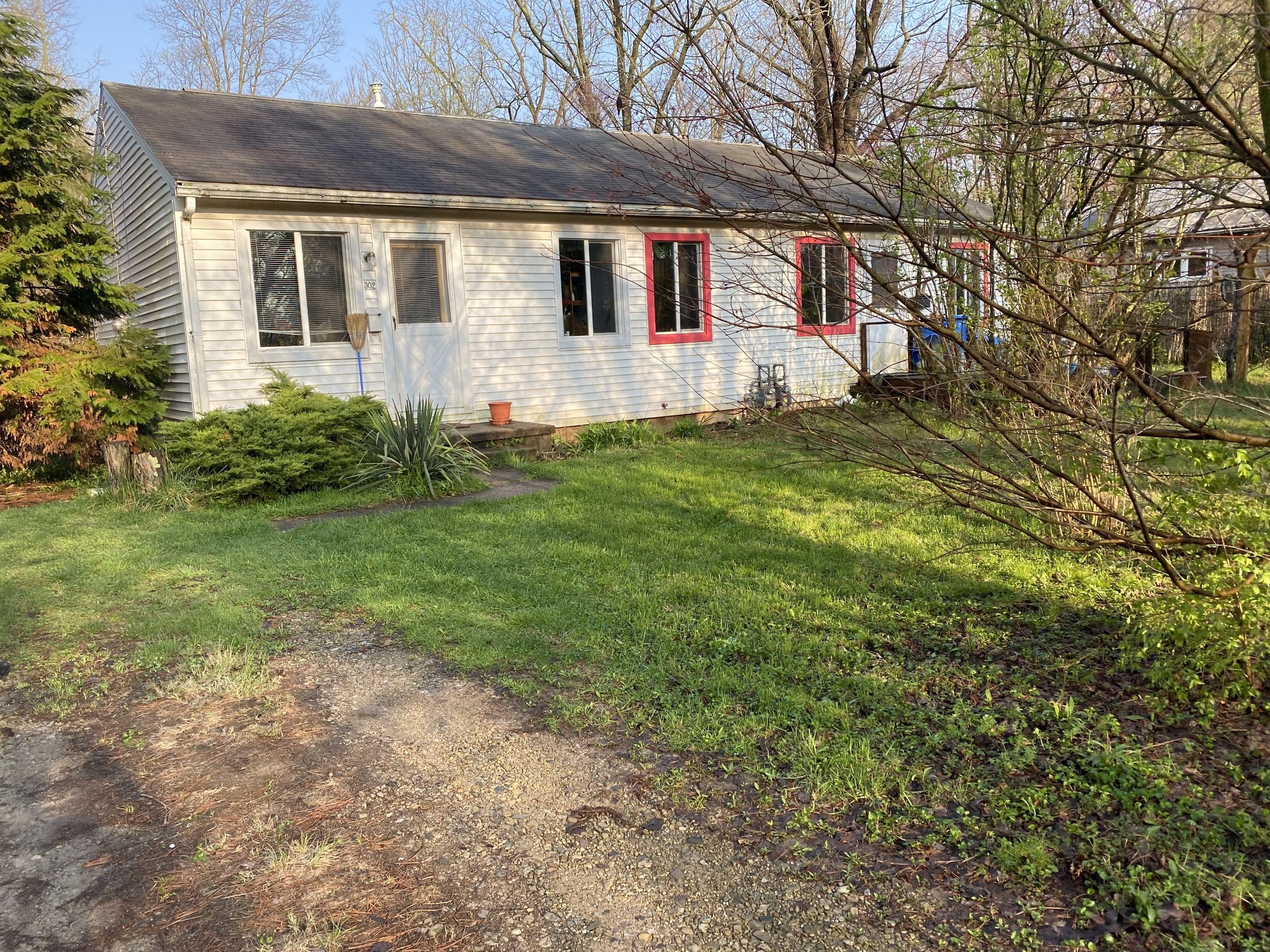 The white ranch house and its old dark roof from the back yard, before the work, Yellow Springs, Ohio.