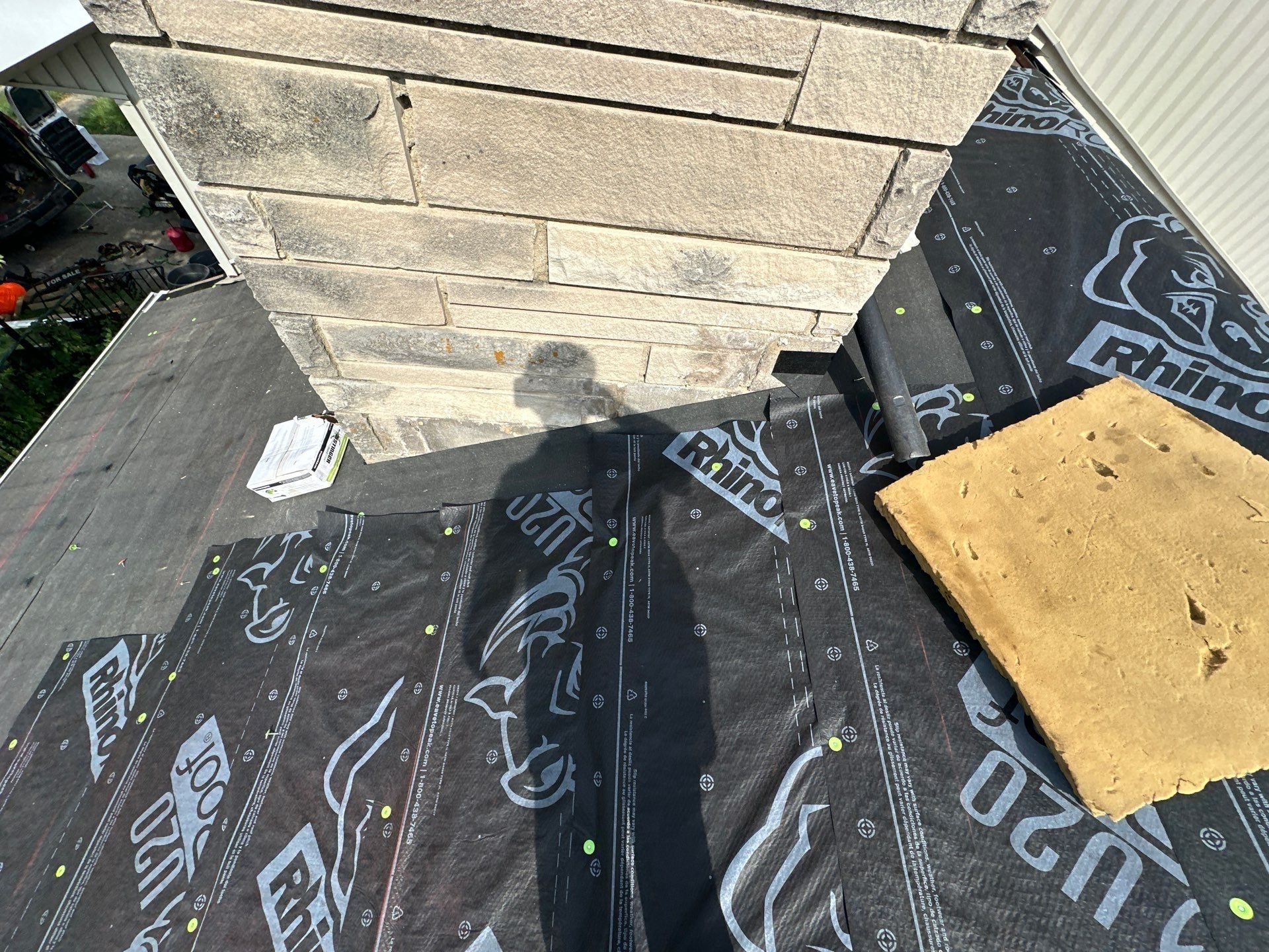 Underlayment and ice and water shield at the base of the stone chimney, Fairborn, Ohio.