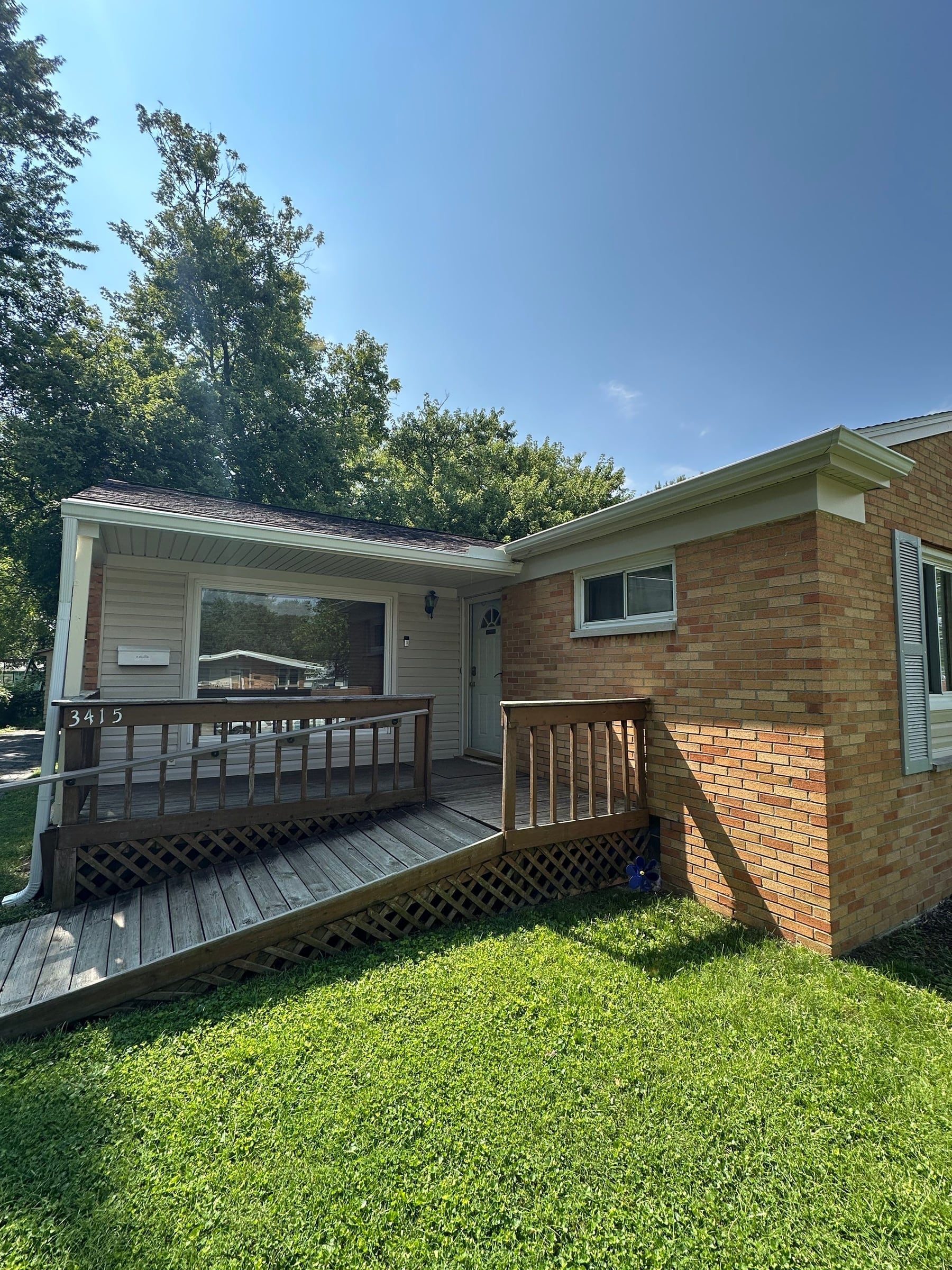 Tan brick ranch, ramp and porch eave