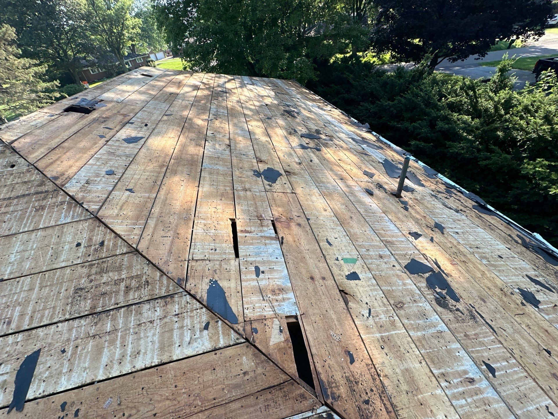 Cleared plank deck with gaps and broken boards along the hip, Beavercreek, Ohio.