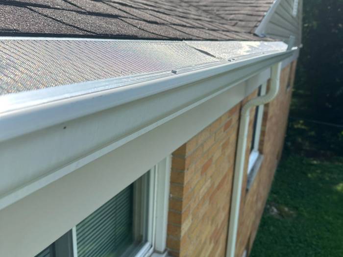 Gutter guard on the new white gutter at the corner of the brick house, Kettering, Ohio.