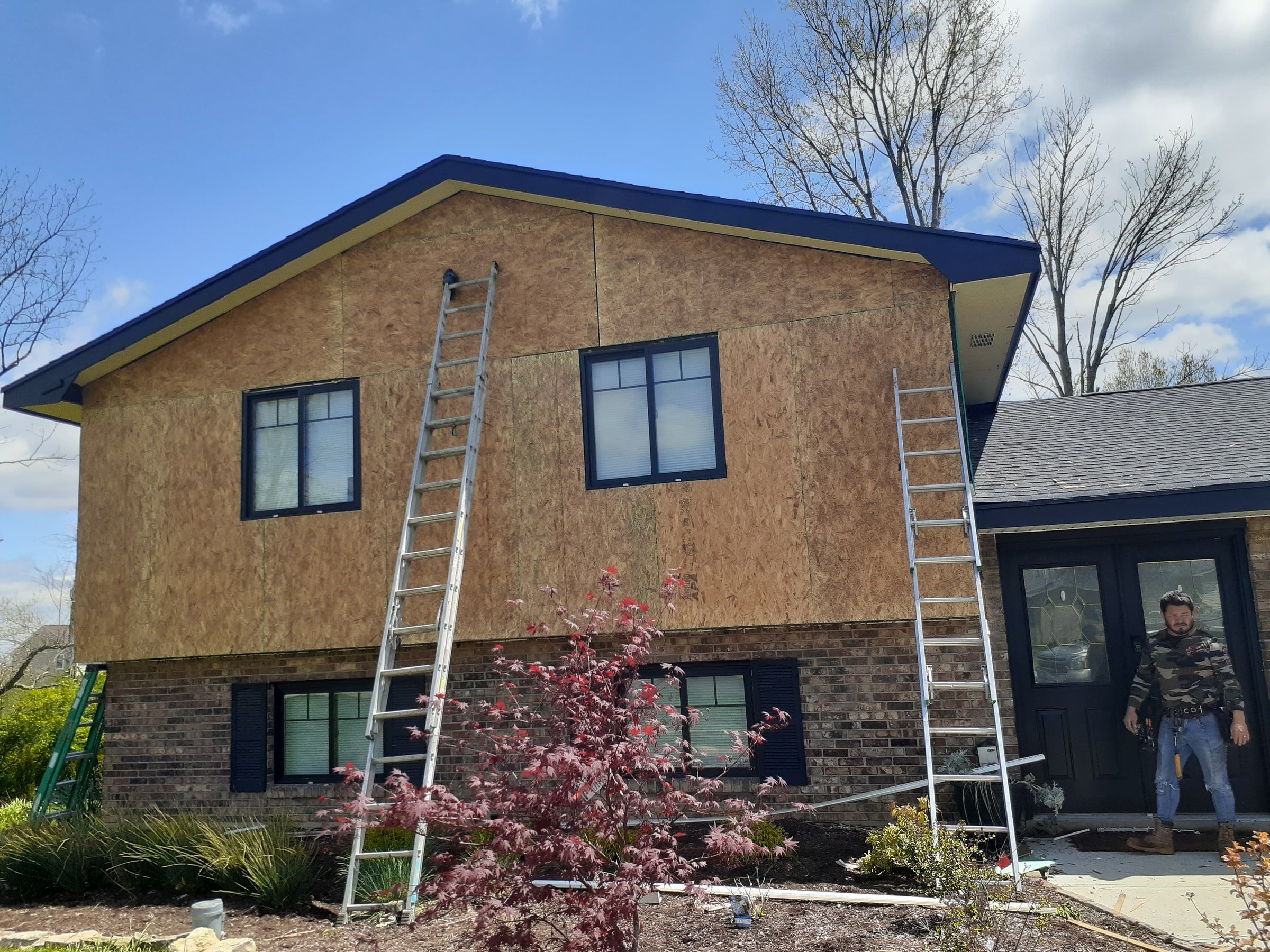 New OSB sheathing on the front gable, with ladders against the wall, Beavercreek, Ohio.