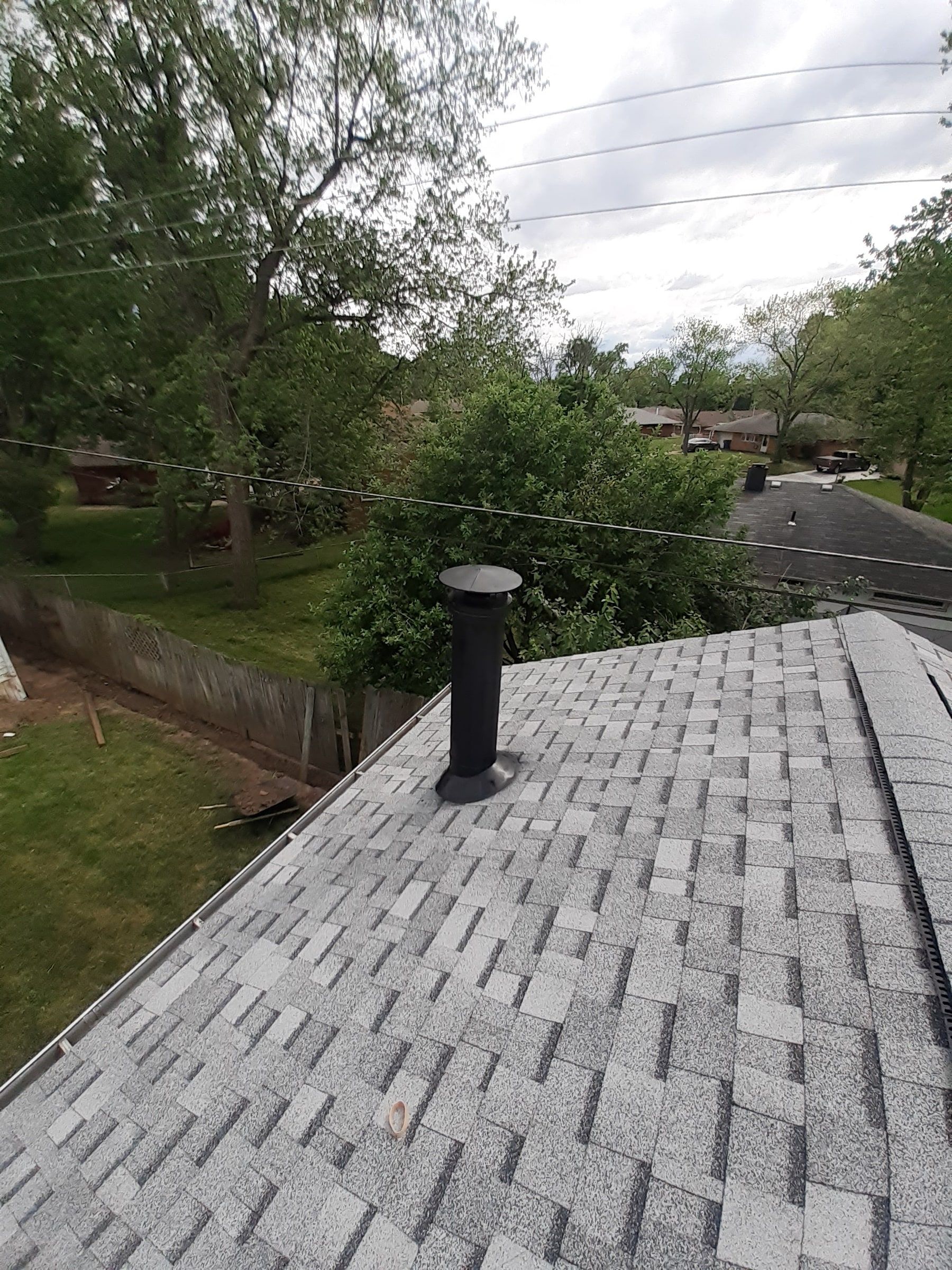 A metal flue rising through the finished shingles, Huber Heights, Ohio.