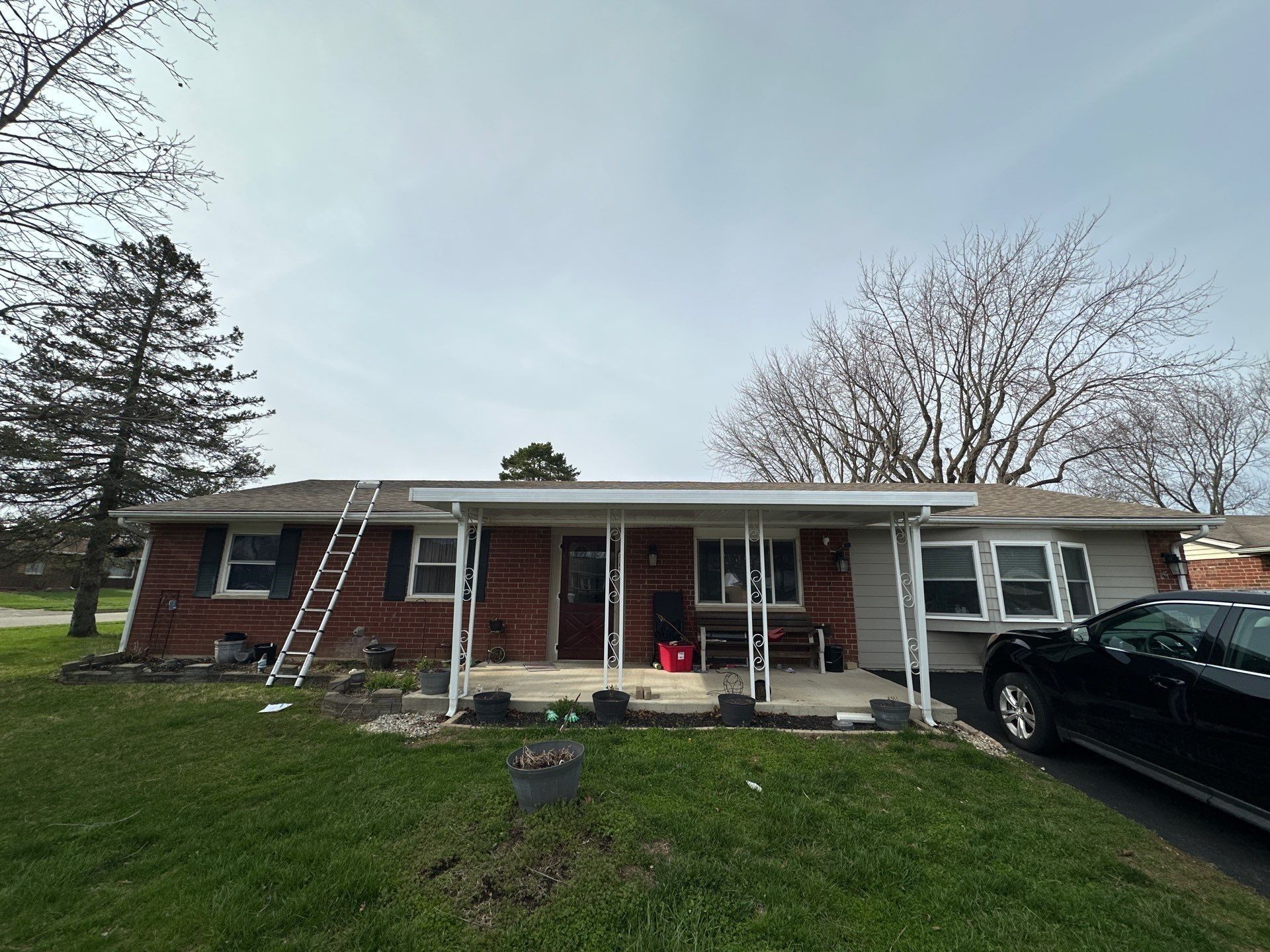 The brick ranch with a ladder at the porch roof, Xenia, Ohio.