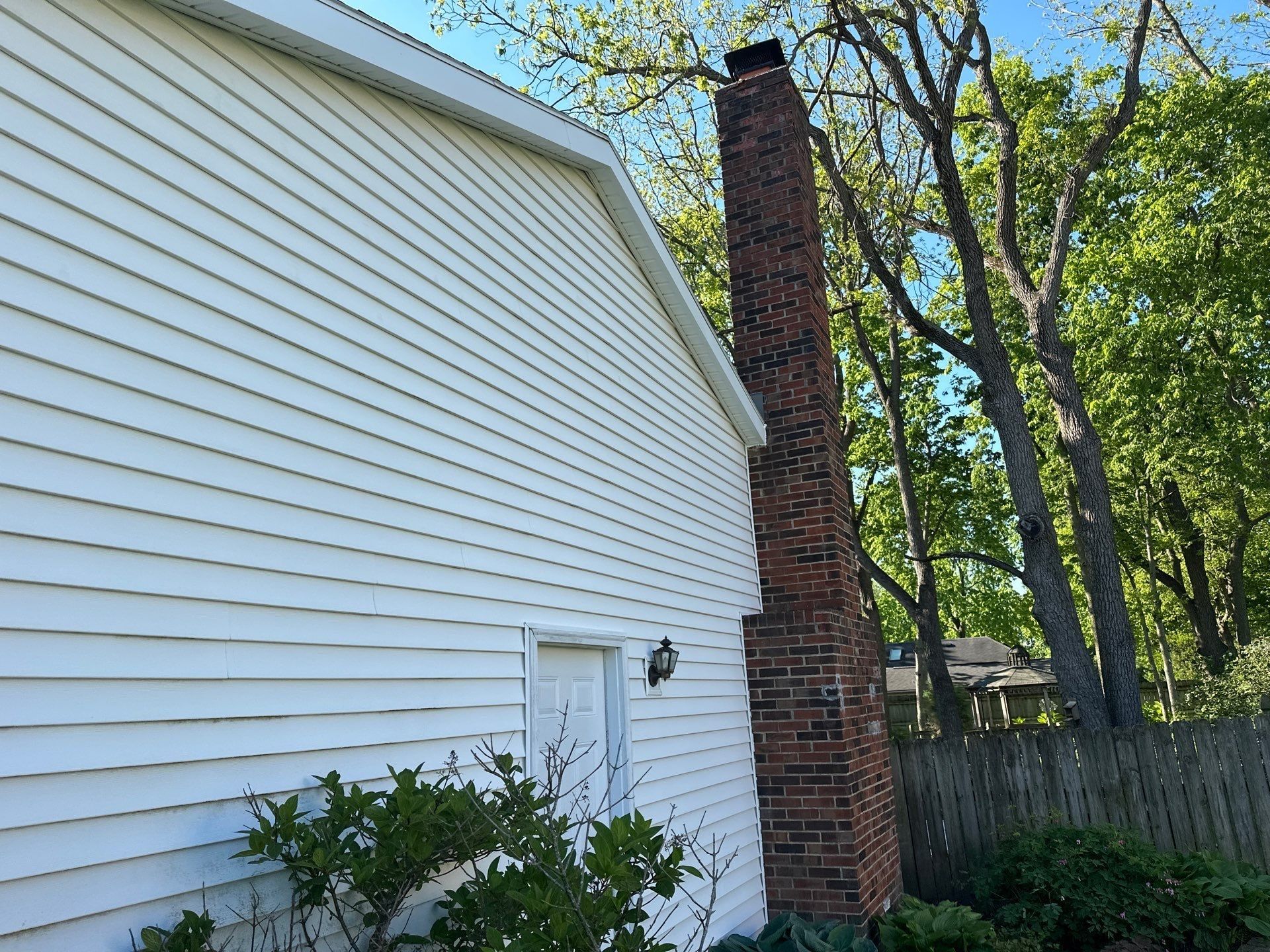 The side wall with new metal-wrapped fascia up to the chimney, Bellbrook, Ohio.