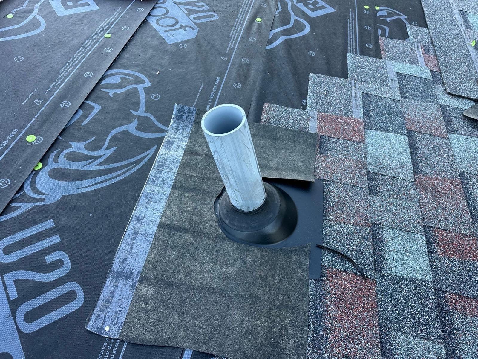 A new pipe boot over the underlayment, with the first shingles beside it, West Carrollton, Ohio.