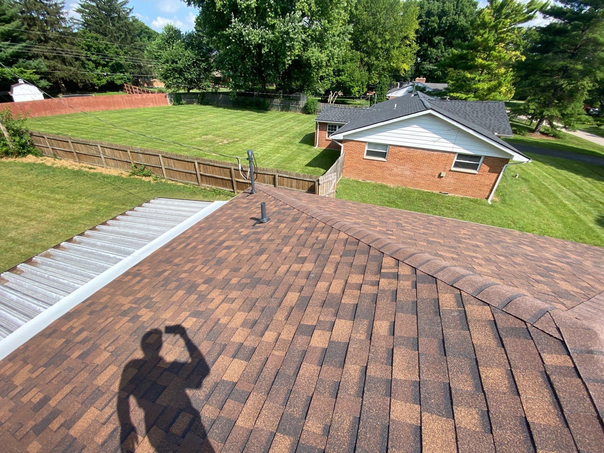 New shingle slope above the metal patio cover with a pipe vent, Beavercreek, Ohio.