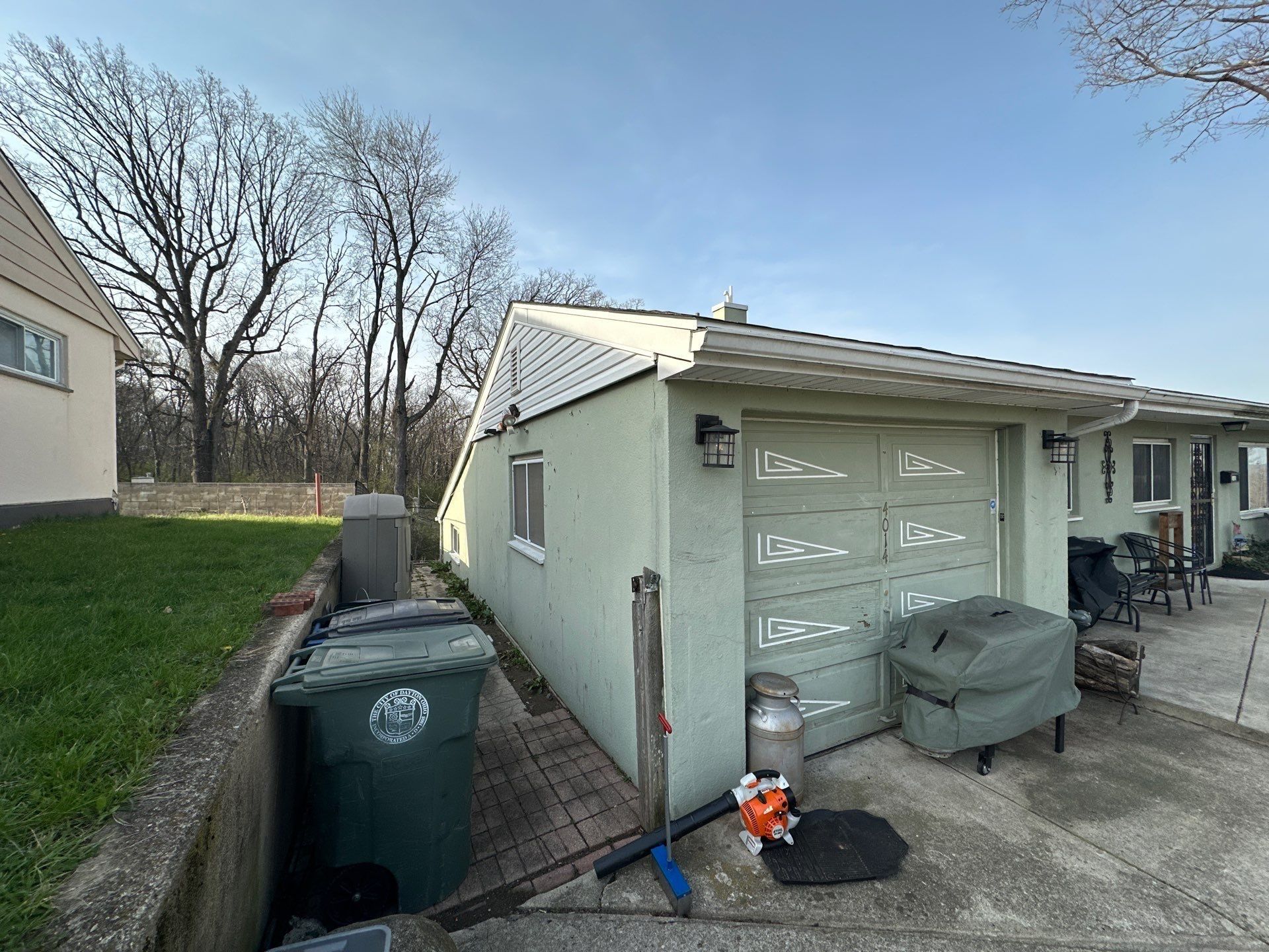 Detached garage, white door and bins