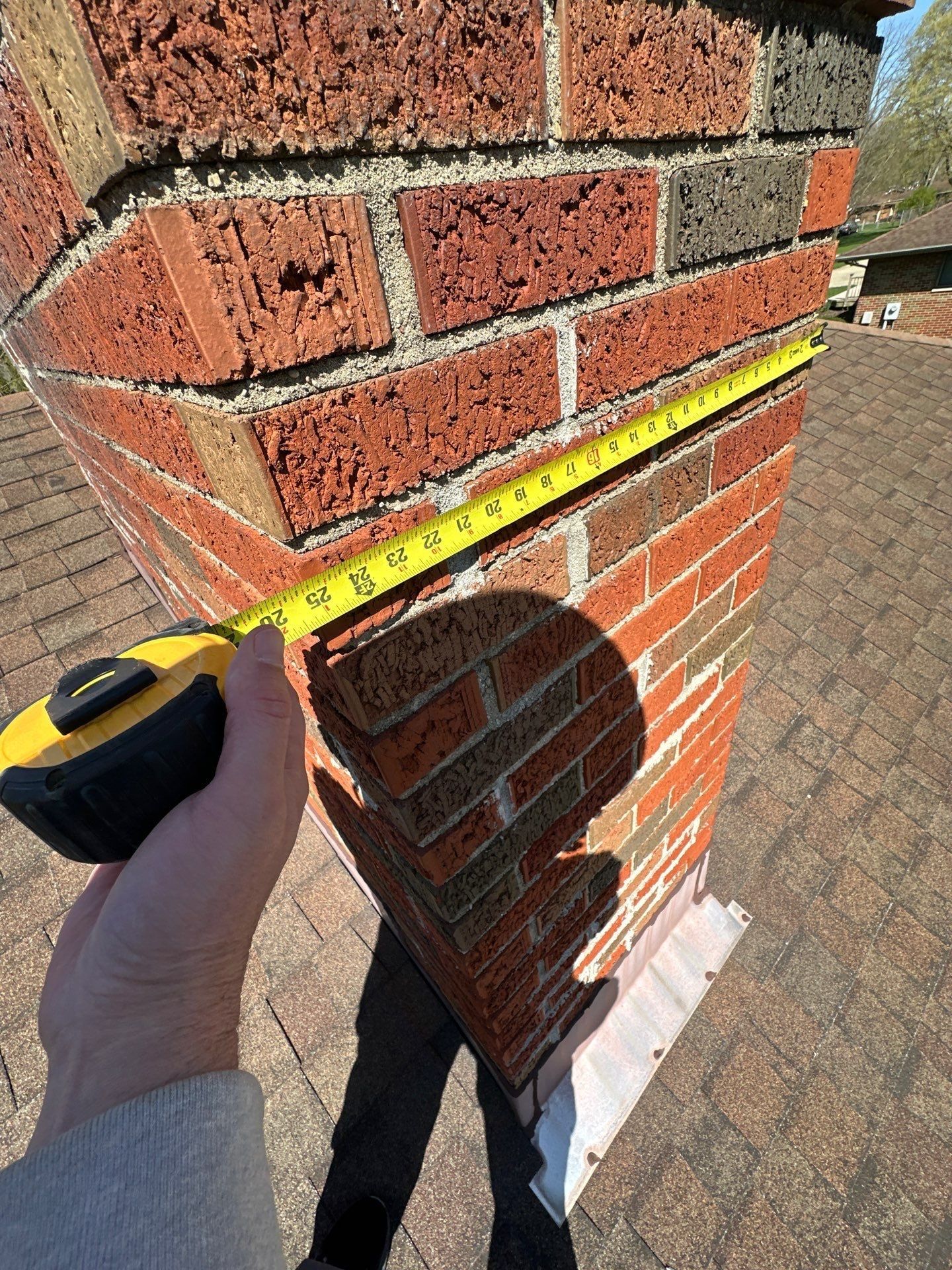 Tape measure across a second chimney side above the old shingles, Beavercreek, Ohio.