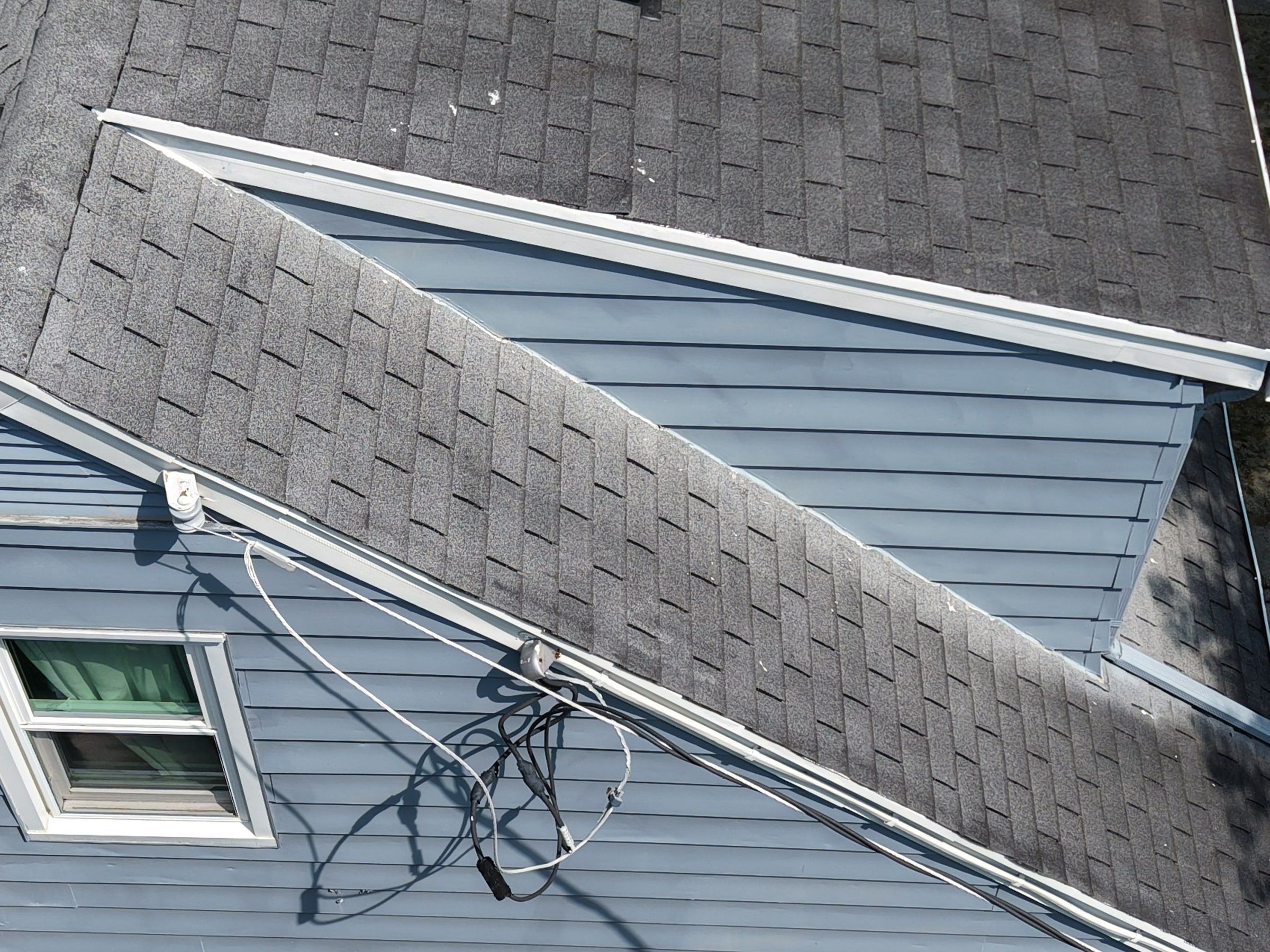 The old roof where a lower section meets the siding, with wires at the eave, Beavercreek, Ohio.