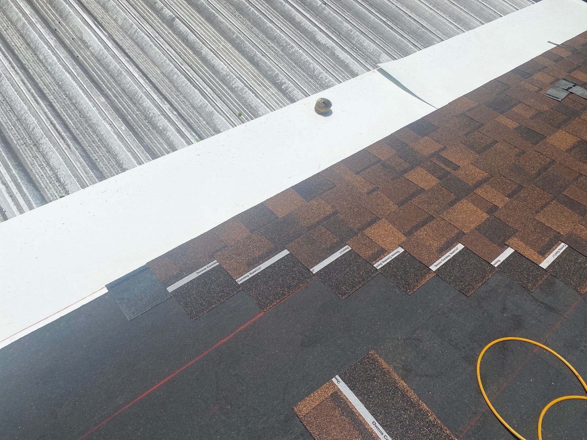 First shingle courses running beside the metal patio cover transition, Beavercreek, Ohio.