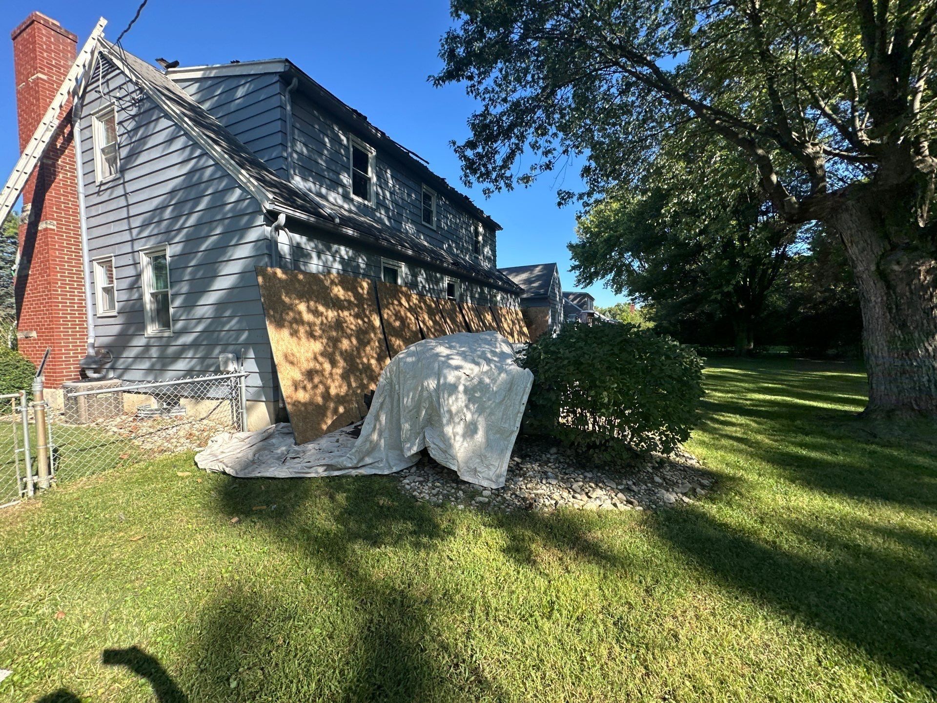 Plywood leaned over the side windows, with a ladder up to the roof, Beavercreek, Ohio.