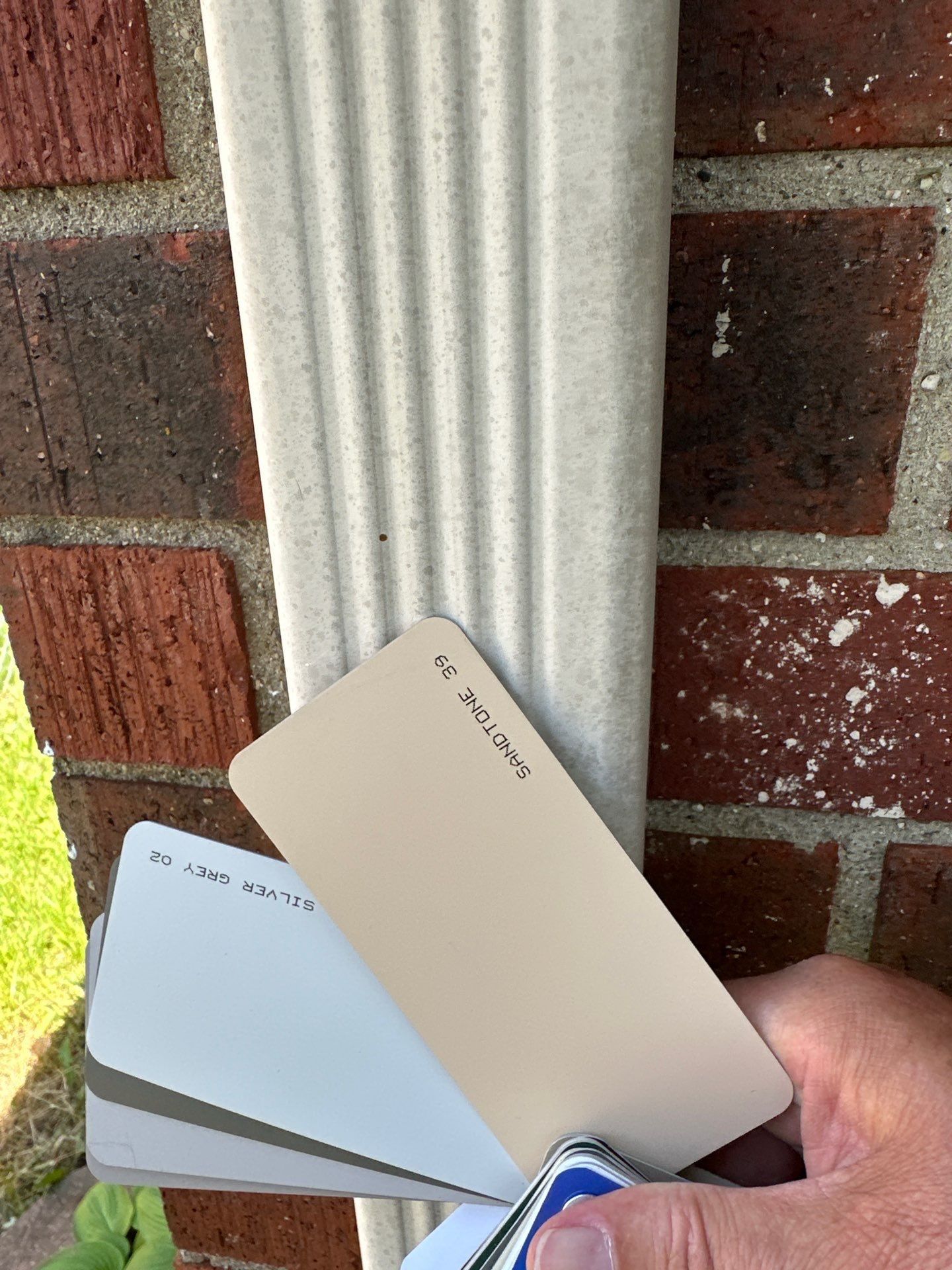 Two color chips against the old downspout