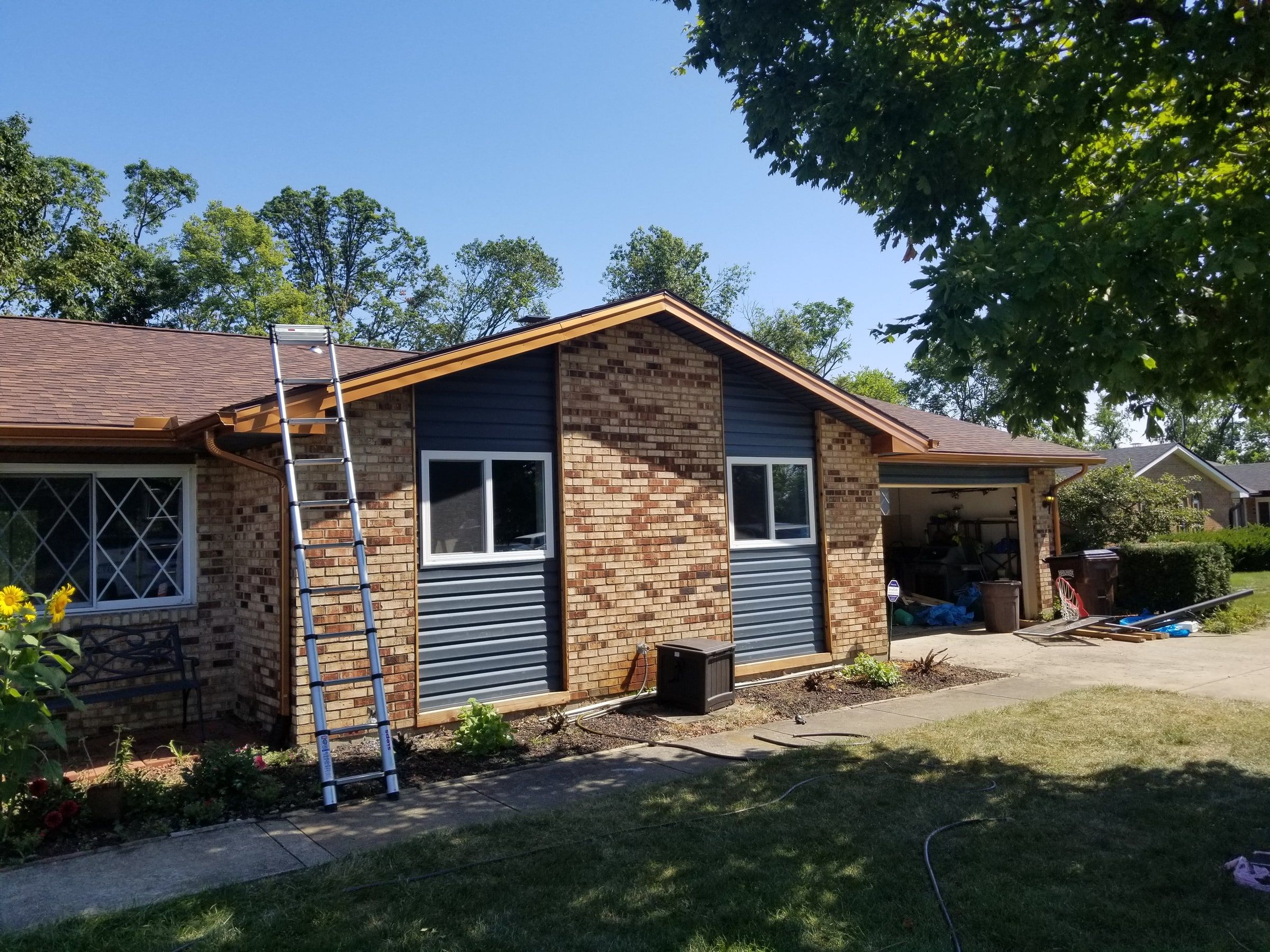 The brick wing with blue-gray siding panels and copper-colored trim, Beavercreek, Ohio.