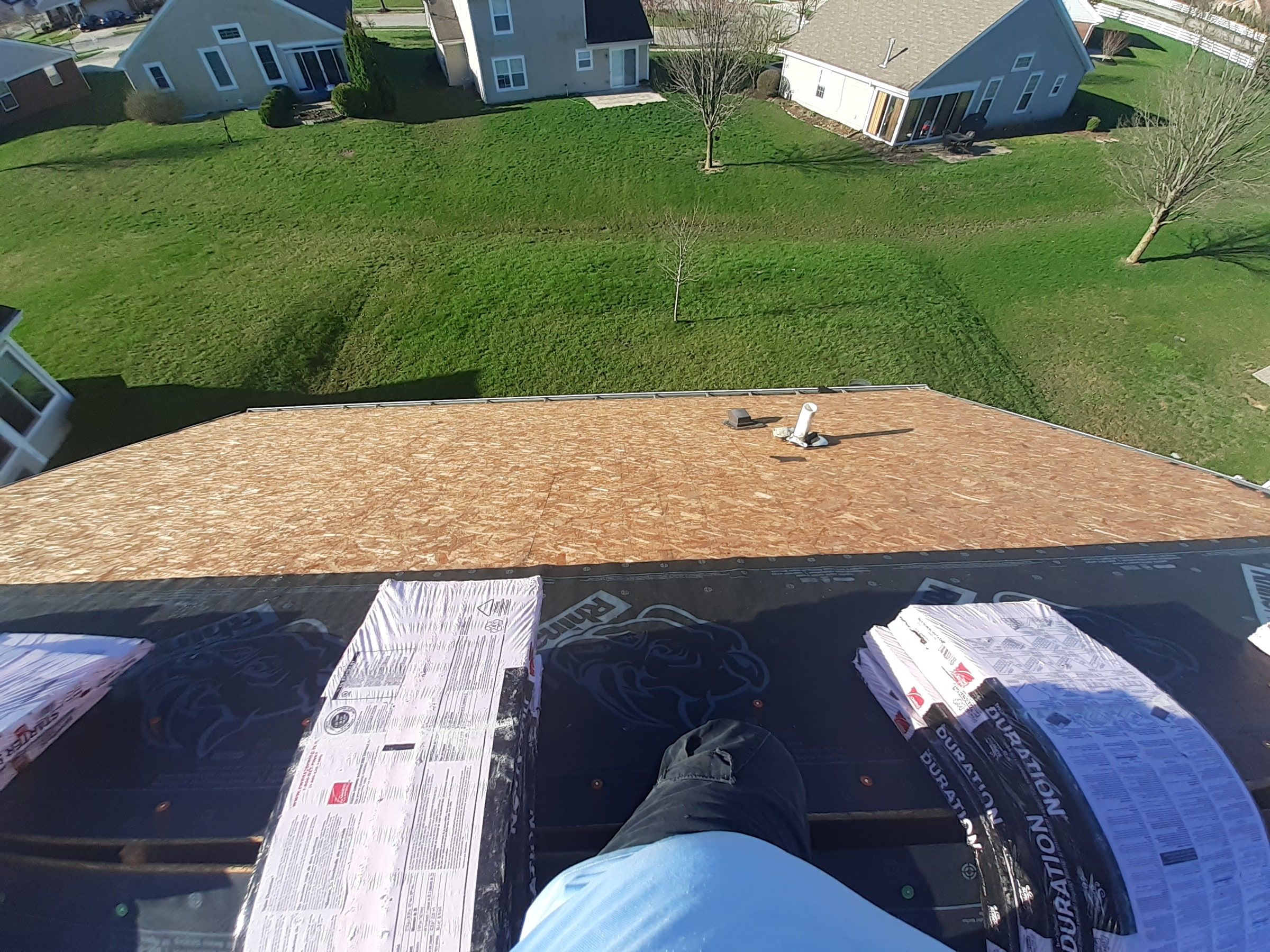 The clean roof deck from above the staged bundles, with the back yard beyond, Xenia, Ohio.
