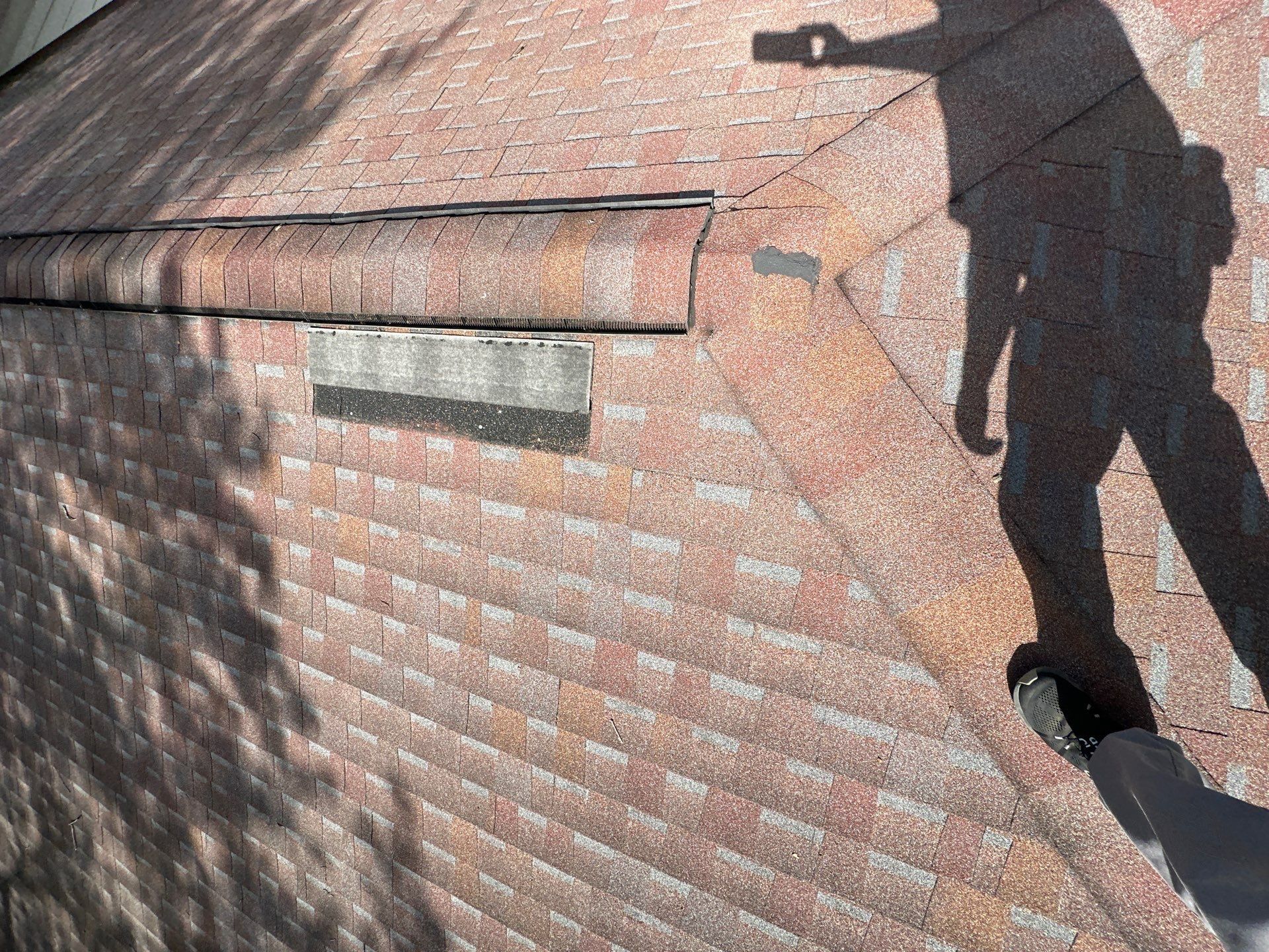 A wind-creased shingle flipped up below the ridge during the inspection, Dayton, Ohio.