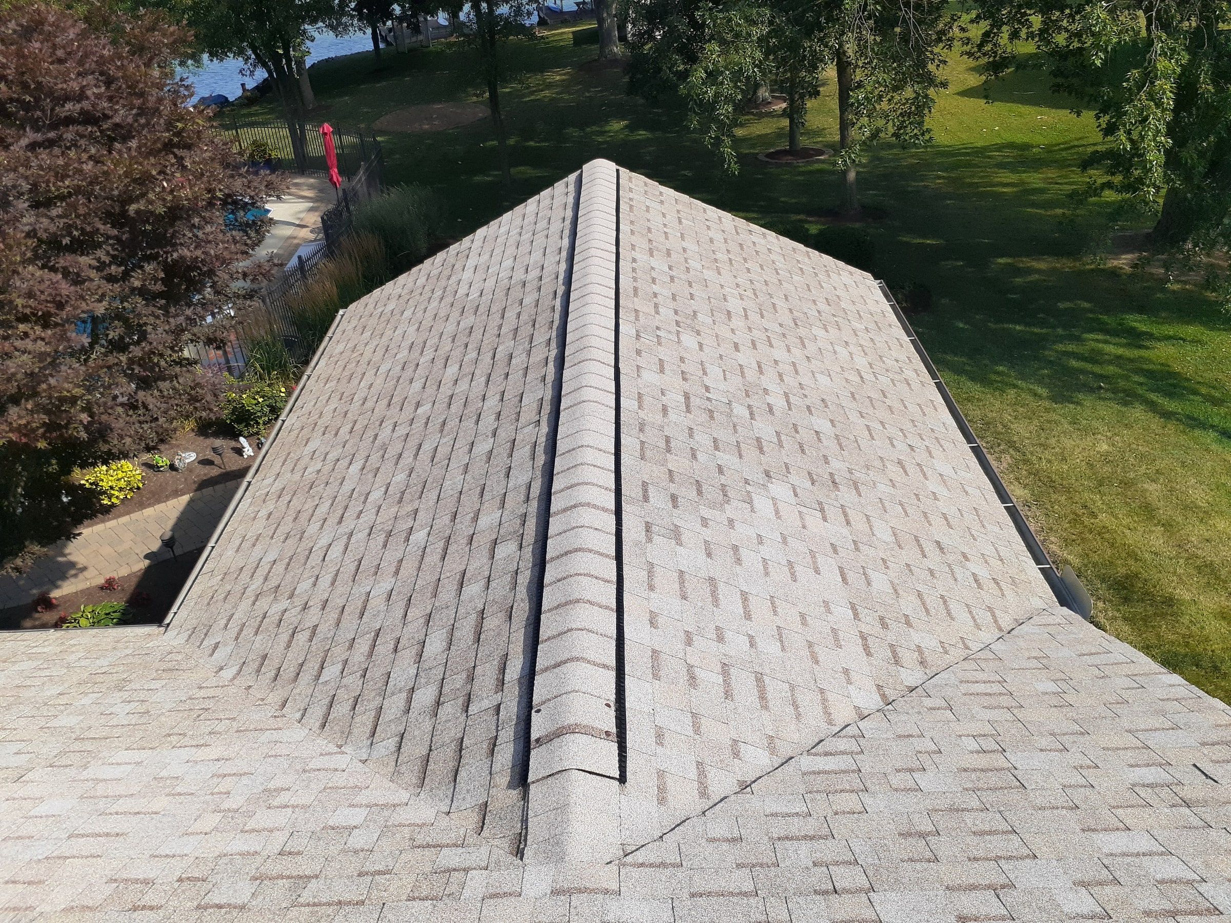 Ridge vent capped along a hip roof over the back garden, Jamestown, Ohio.