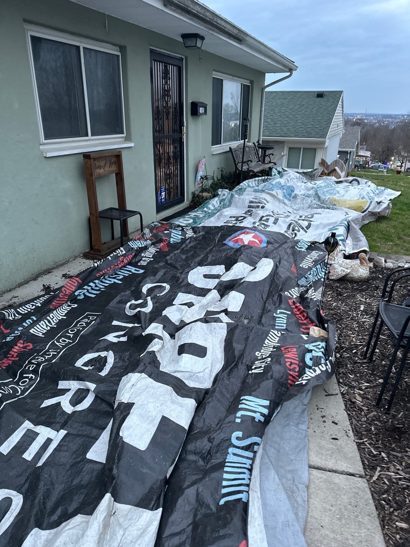Tarps covering the flower bed and walk beside the front door, Dayton, Ohio.