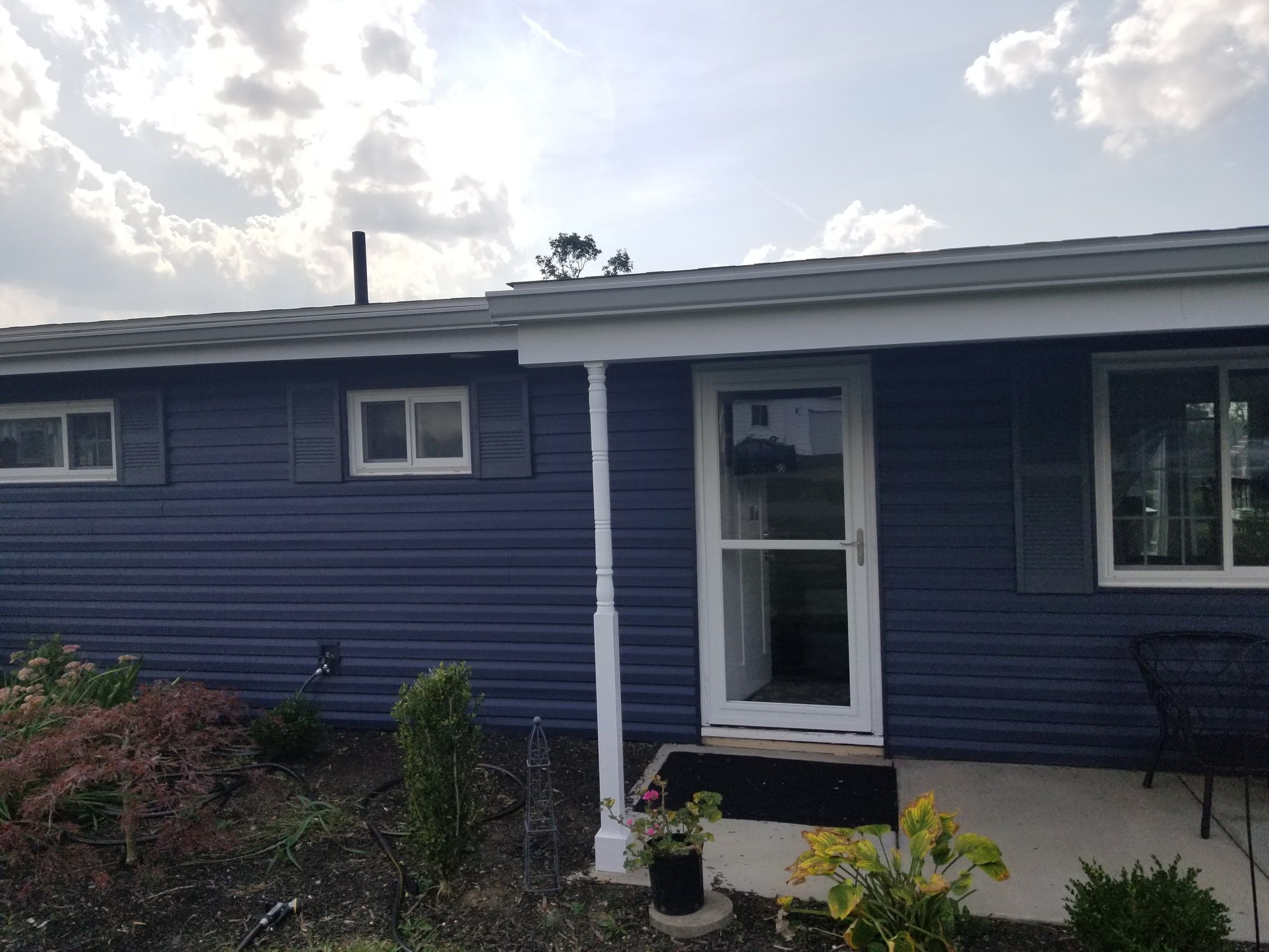 The front entry in blue siding under the white porch roof, Beavercreek, Ohio.