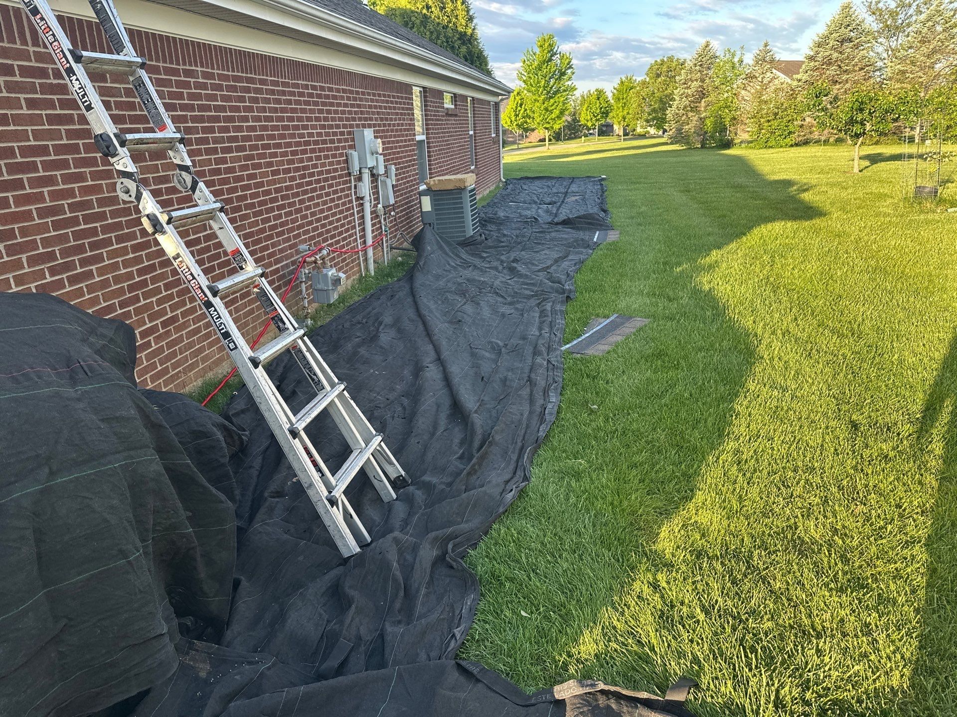 Tarps along the foundation and beds