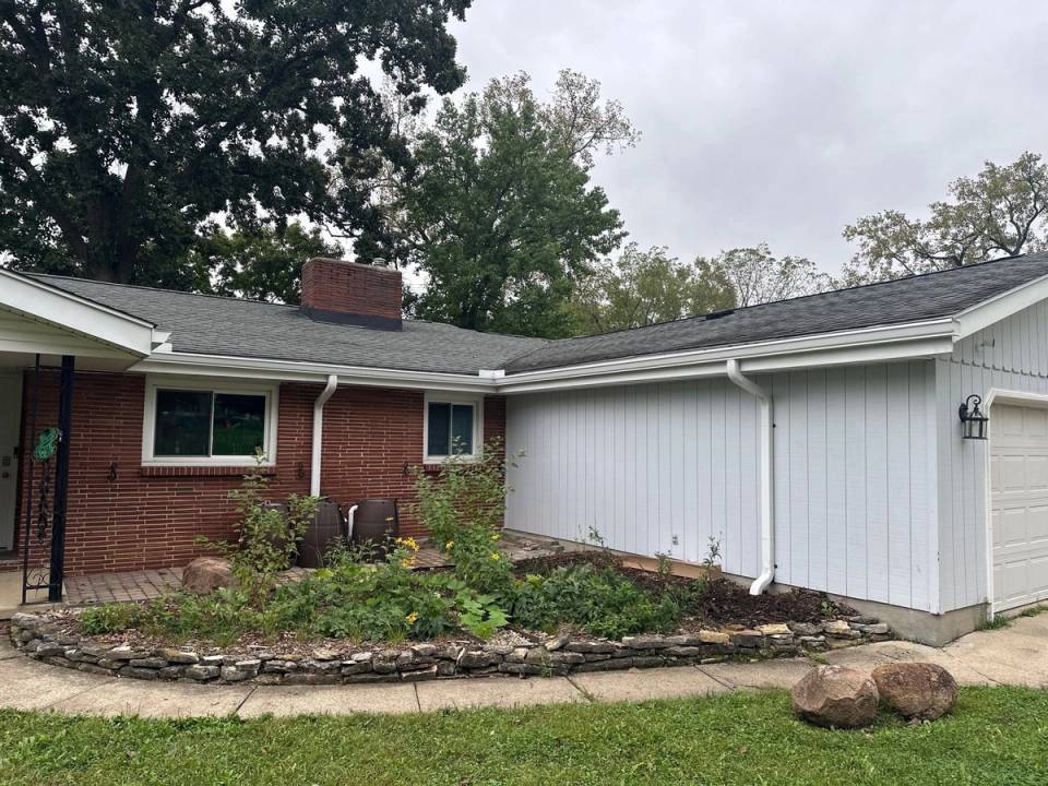 New white seamless gutters and downspouts on a brick and white-sided ranch, West Carrollton, Ohio.
