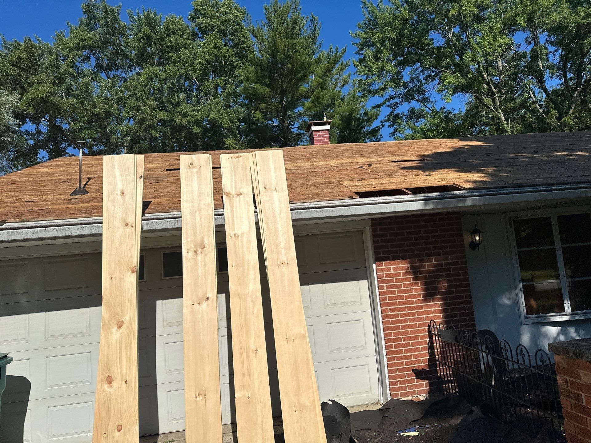 New 1x12 deck boards standing at the garage door, ready for the repair, Beavercreek, Ohio.