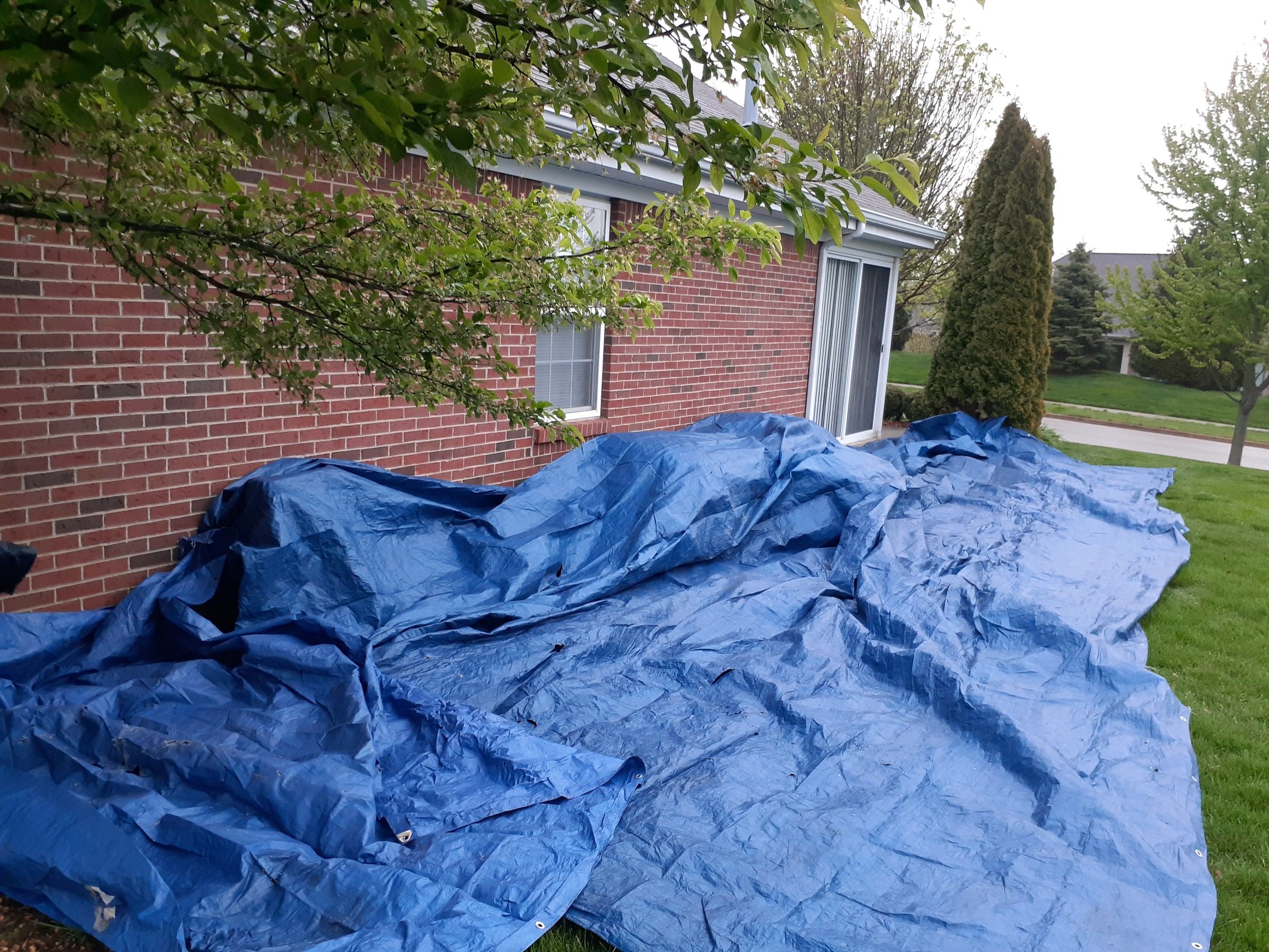 Tarps spread on the lawn along the side of the brick ranch, Xenia, Ohio.