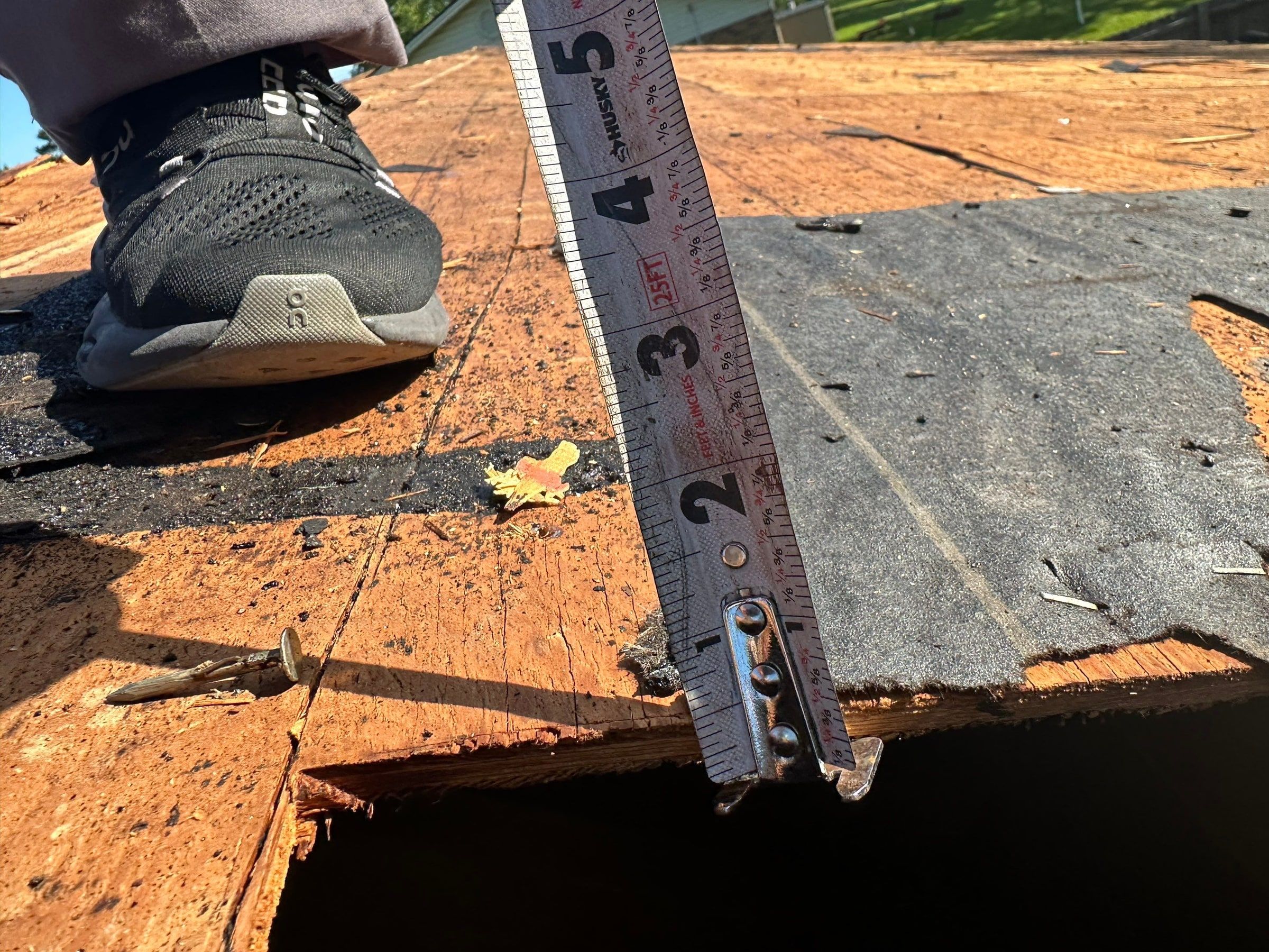 A tape measure in a rotted hole through the deck, Beavercreek, Ohio.