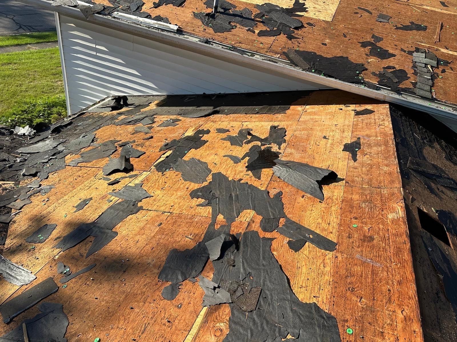 Bare deck and scraps of old shingle along the edge of the lower roof, West Carrollton, Ohio.