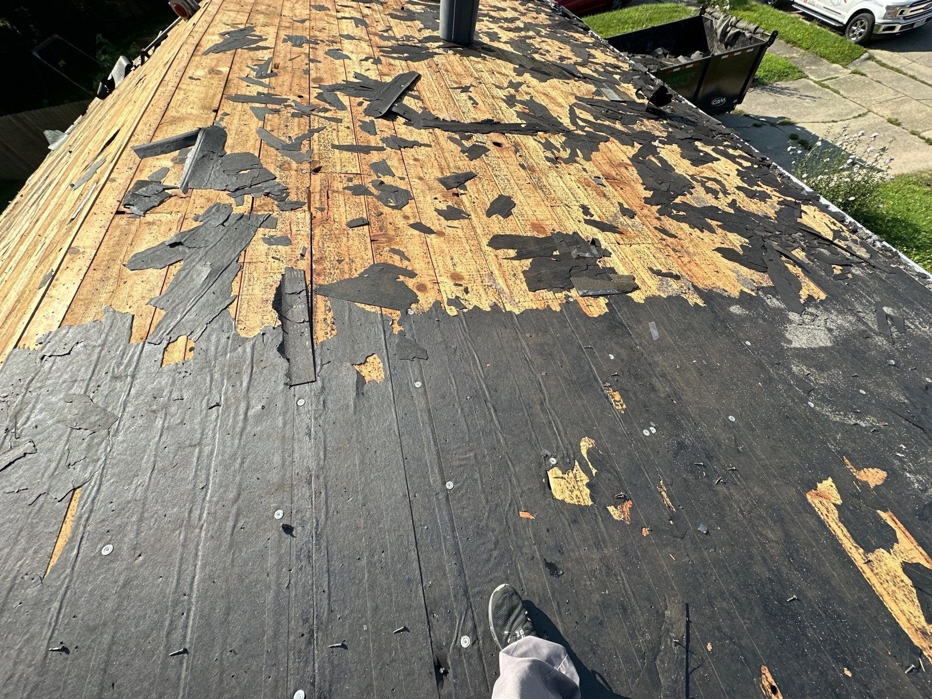 Scraps of old roofing paper still on the board deck during tear-off, Fairborn, Ohio.