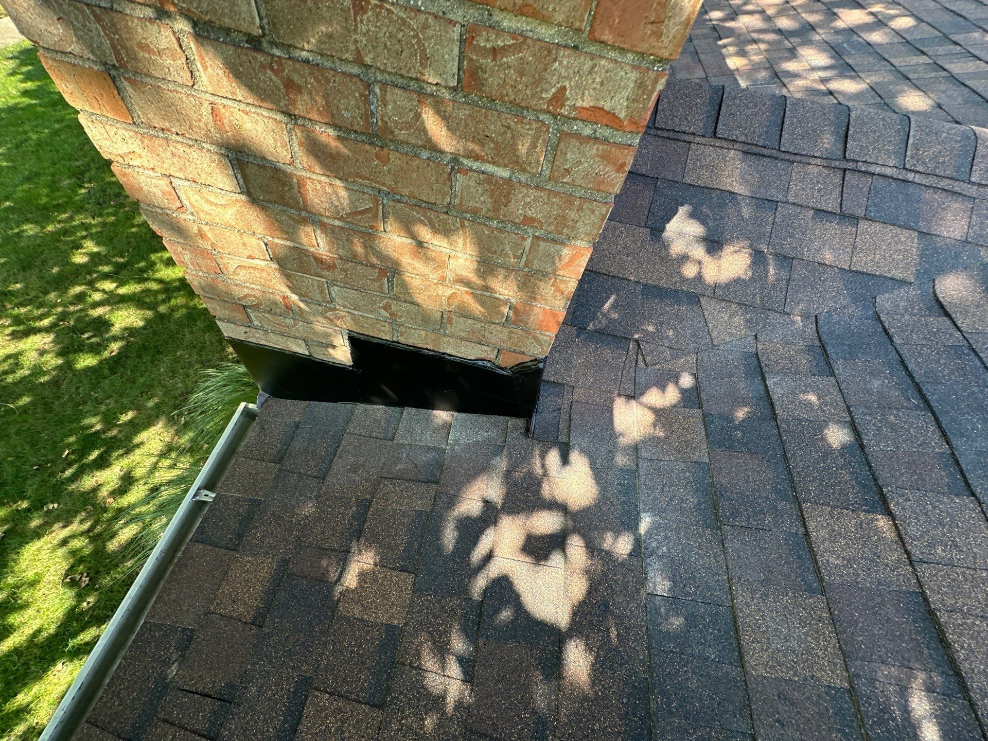New chimney flashing at the base of the brick chimney, from one side, Dayton, Ohio.