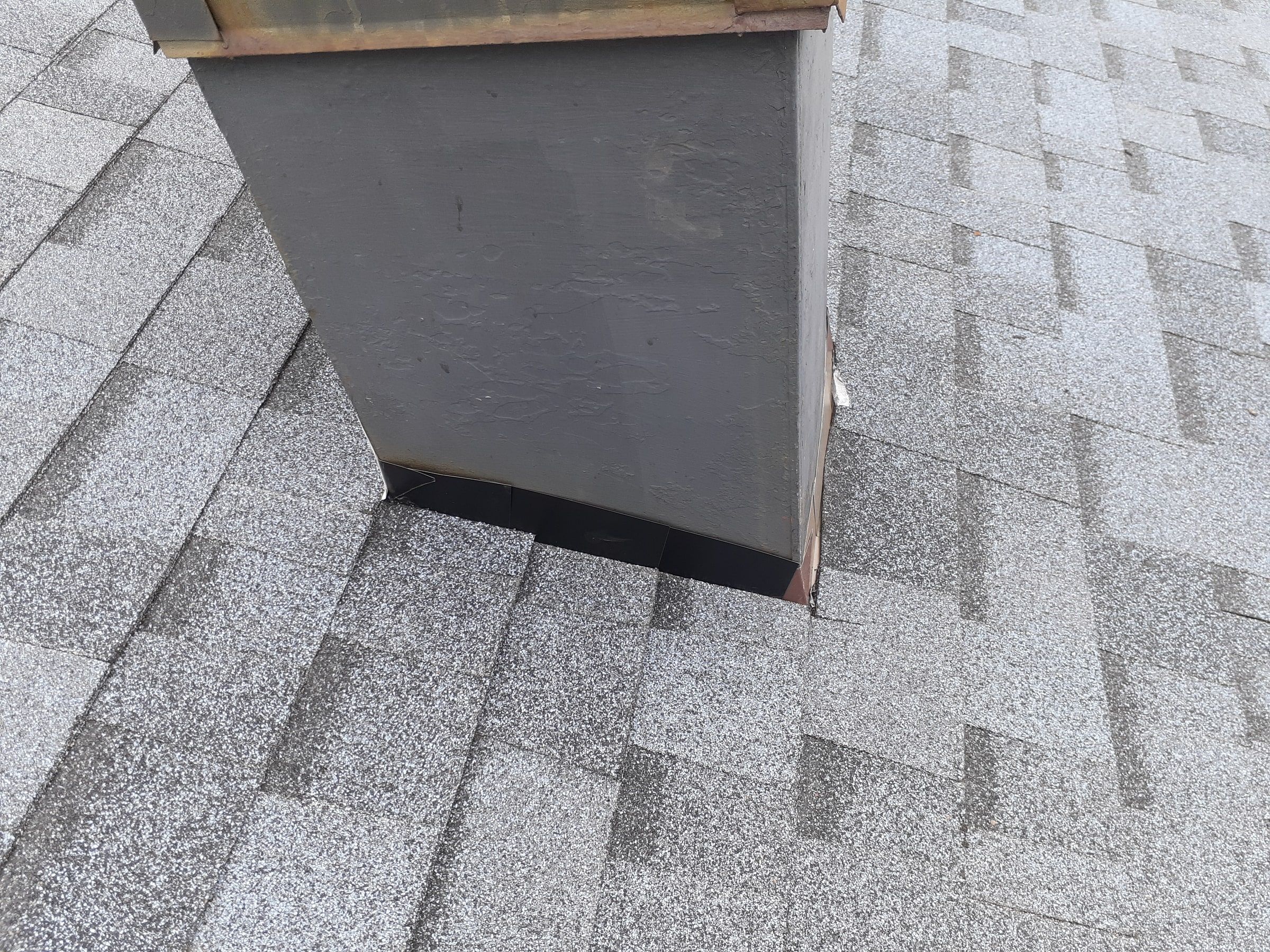 New step flashing along the side of the chimney in the new shingles, Kettering, Ohio.