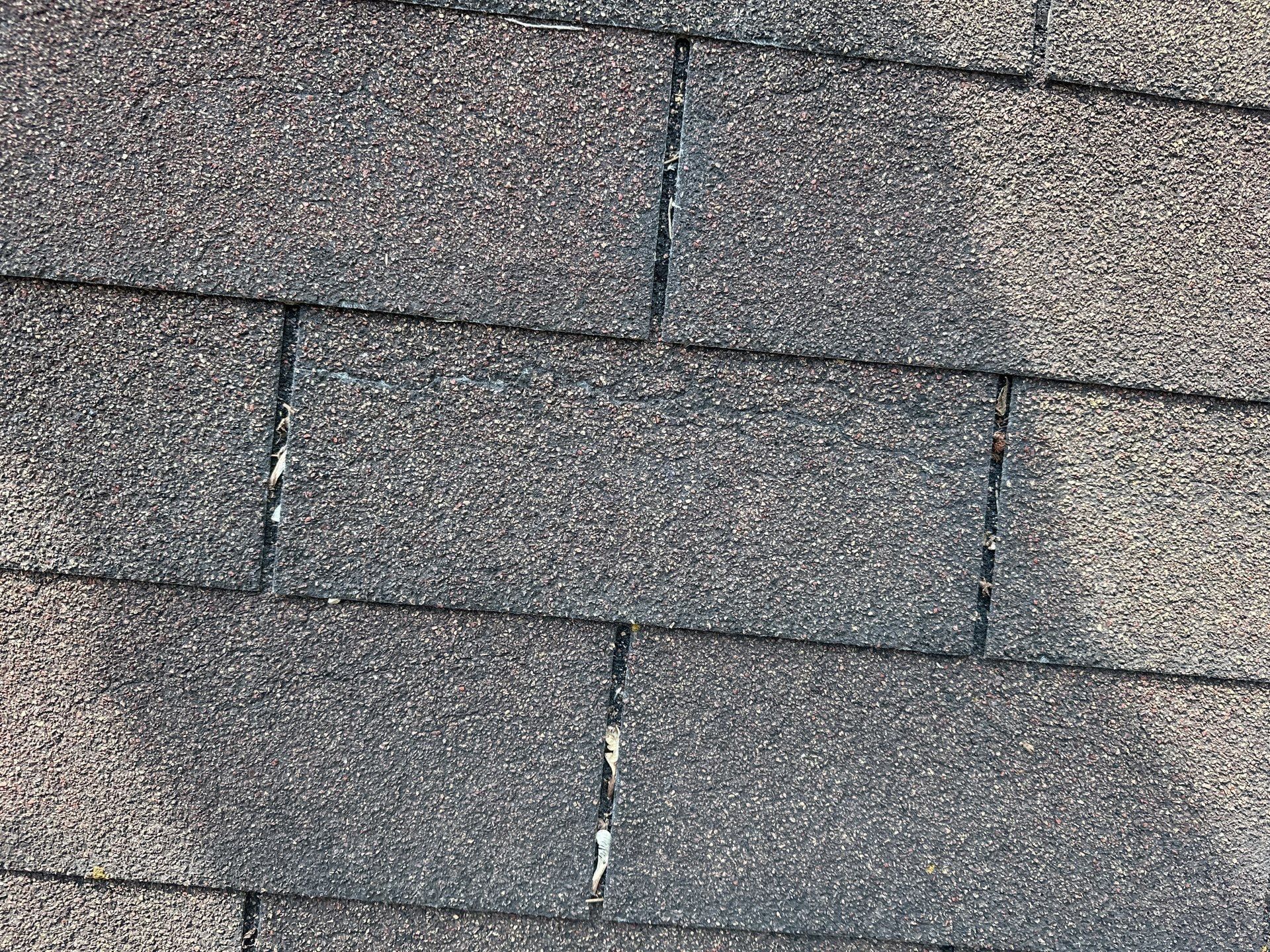Cracked shingle tabs with exposed mat after the spring windstorm, Beavercreek, Ohio.