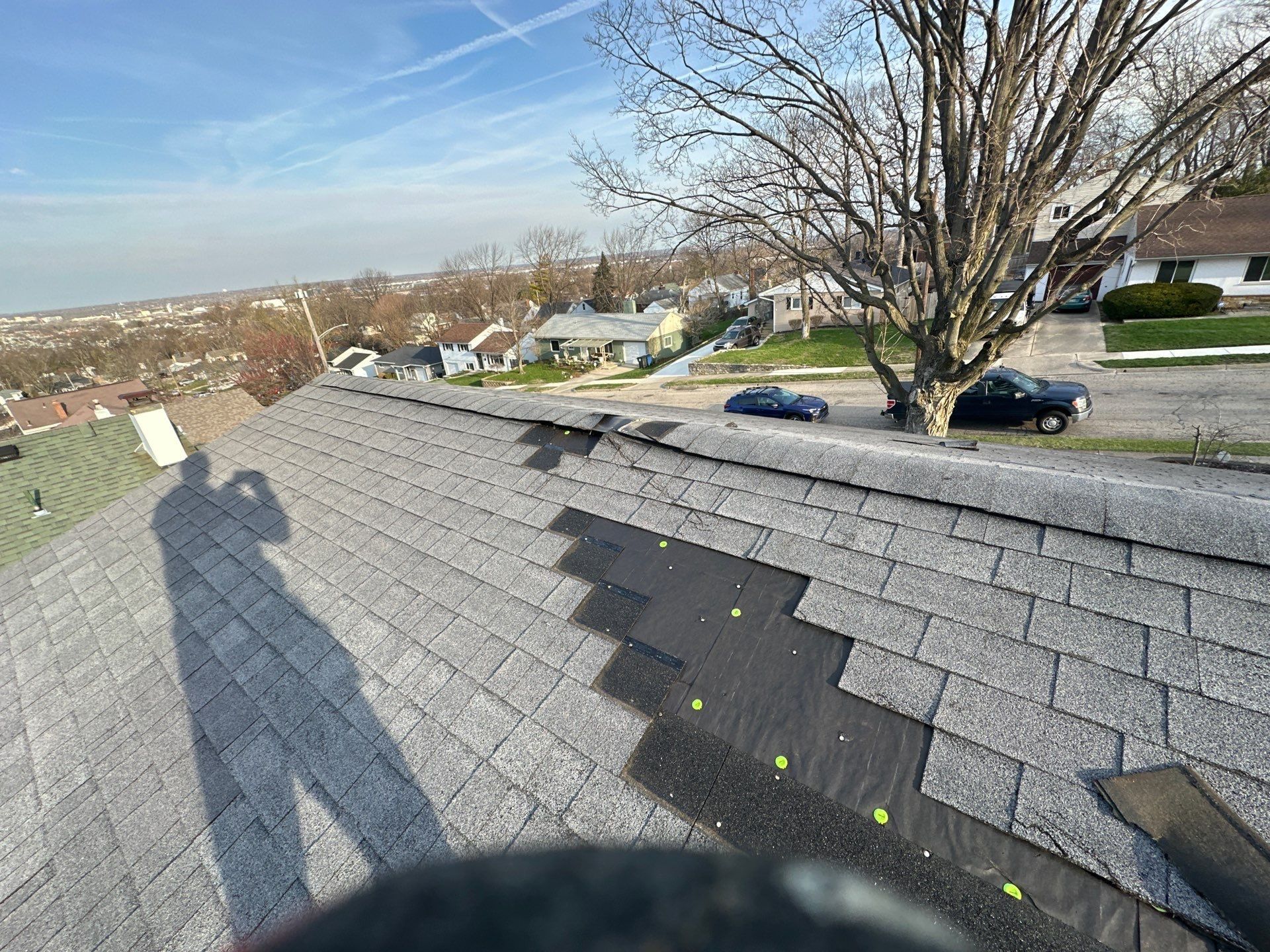 Patched shingles and a torn tab near the top of the old roof, Dayton, Ohio.