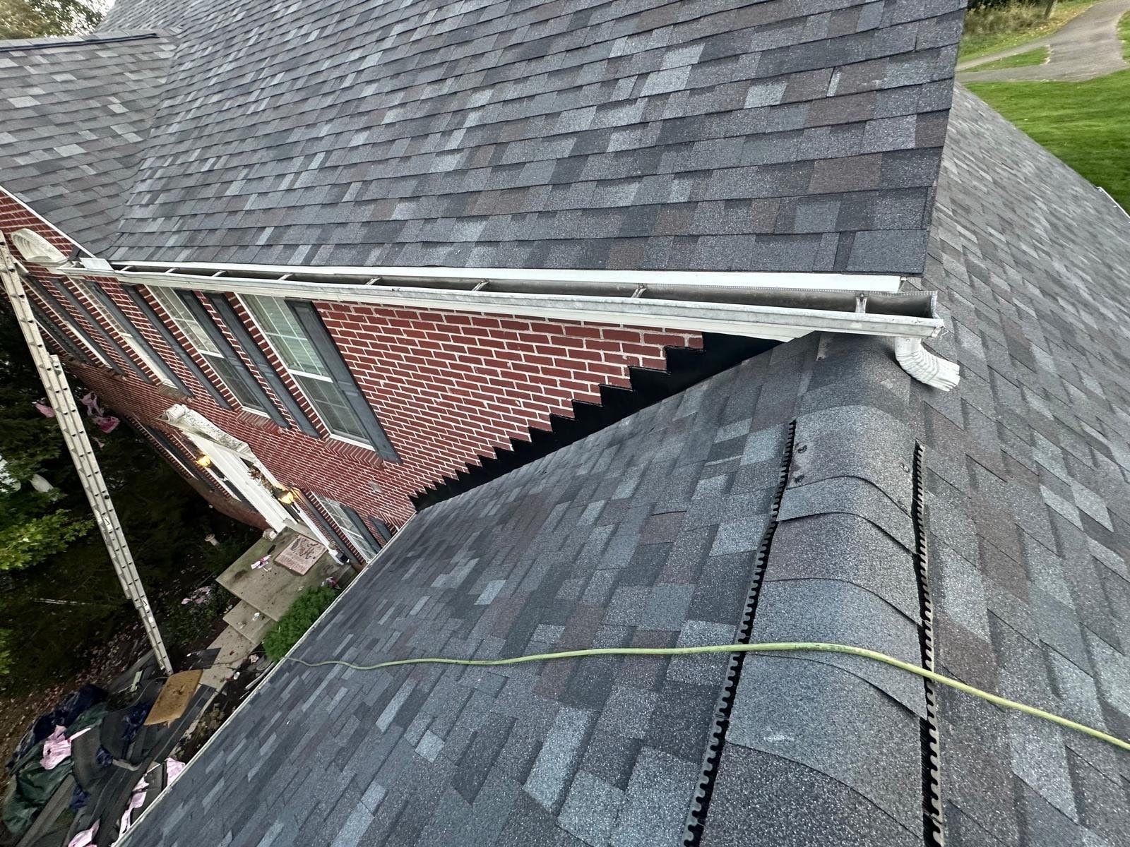 New shingles and flashing where the lower roof meets the brick wall, Beavercreek, Ohio.