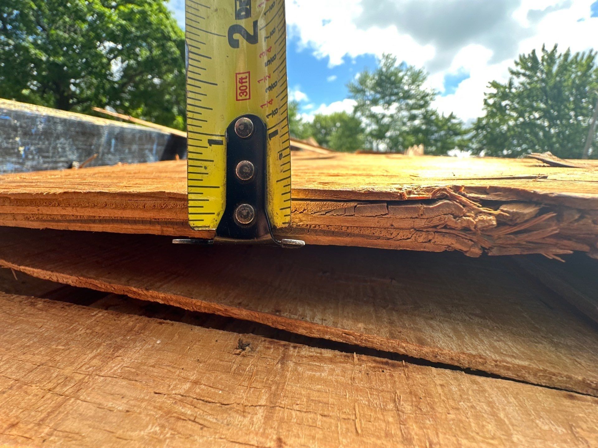 A tape measure against a piece of the old sheathing, too thin for a roof deck, Dayton, Ohio.