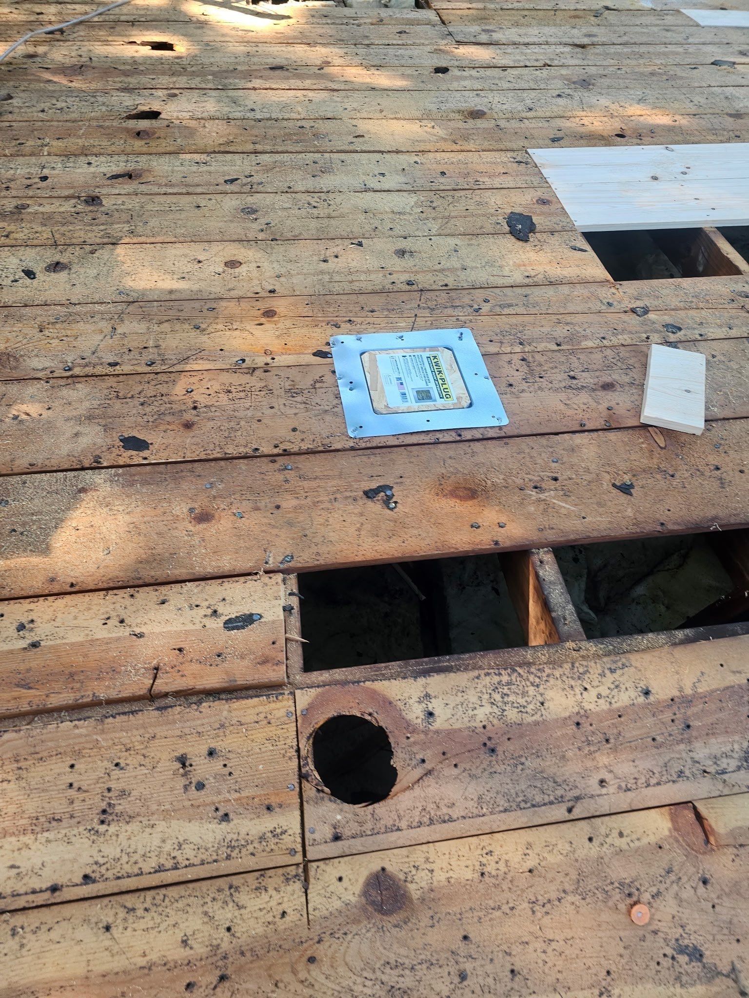 Rotted boards cut out of the deck, open to the attic, beside a new vent base, Kettering, Ohio.