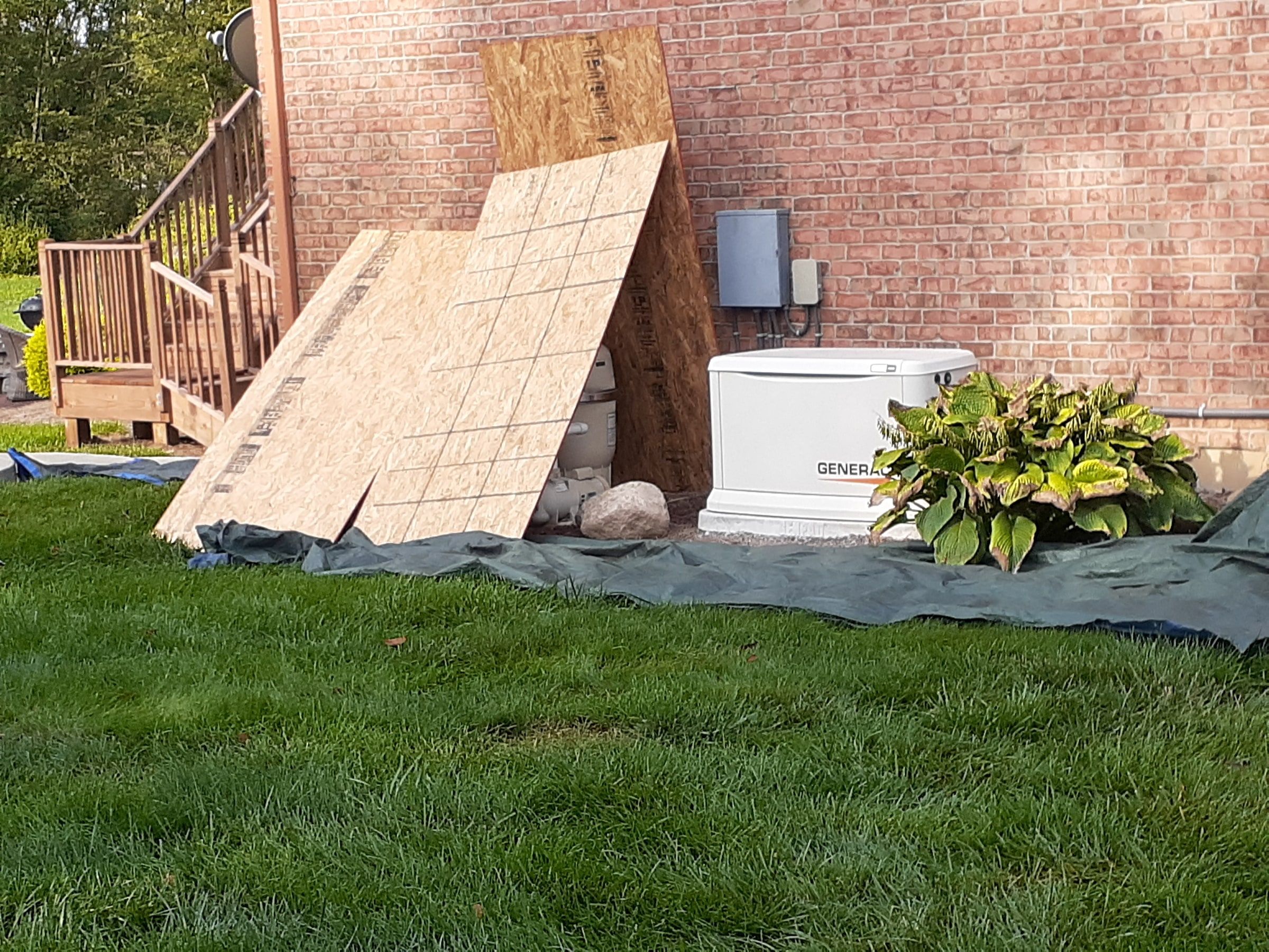OSB sheets and tarp by the generator