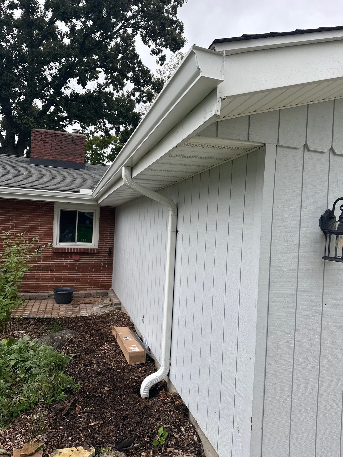 A new downspout in the corner where the brick meets the white siding, West Carrollton, Ohio.