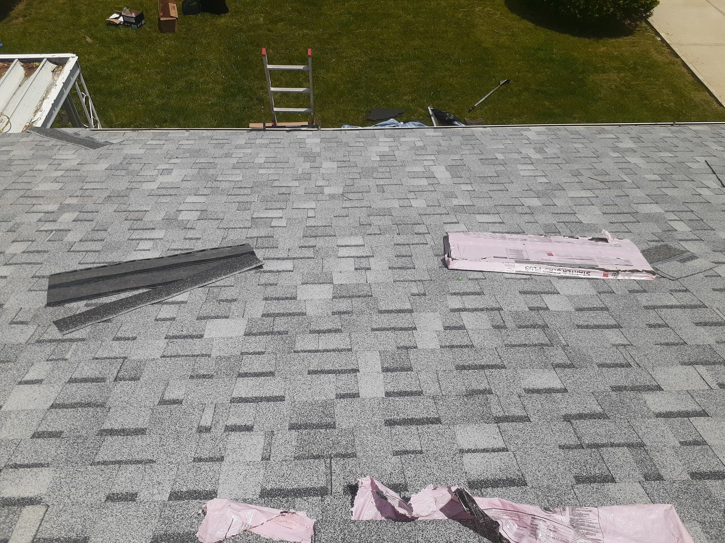 New shingles across the back slope with bundle wrappers on top, Huber Heights, Ohio.