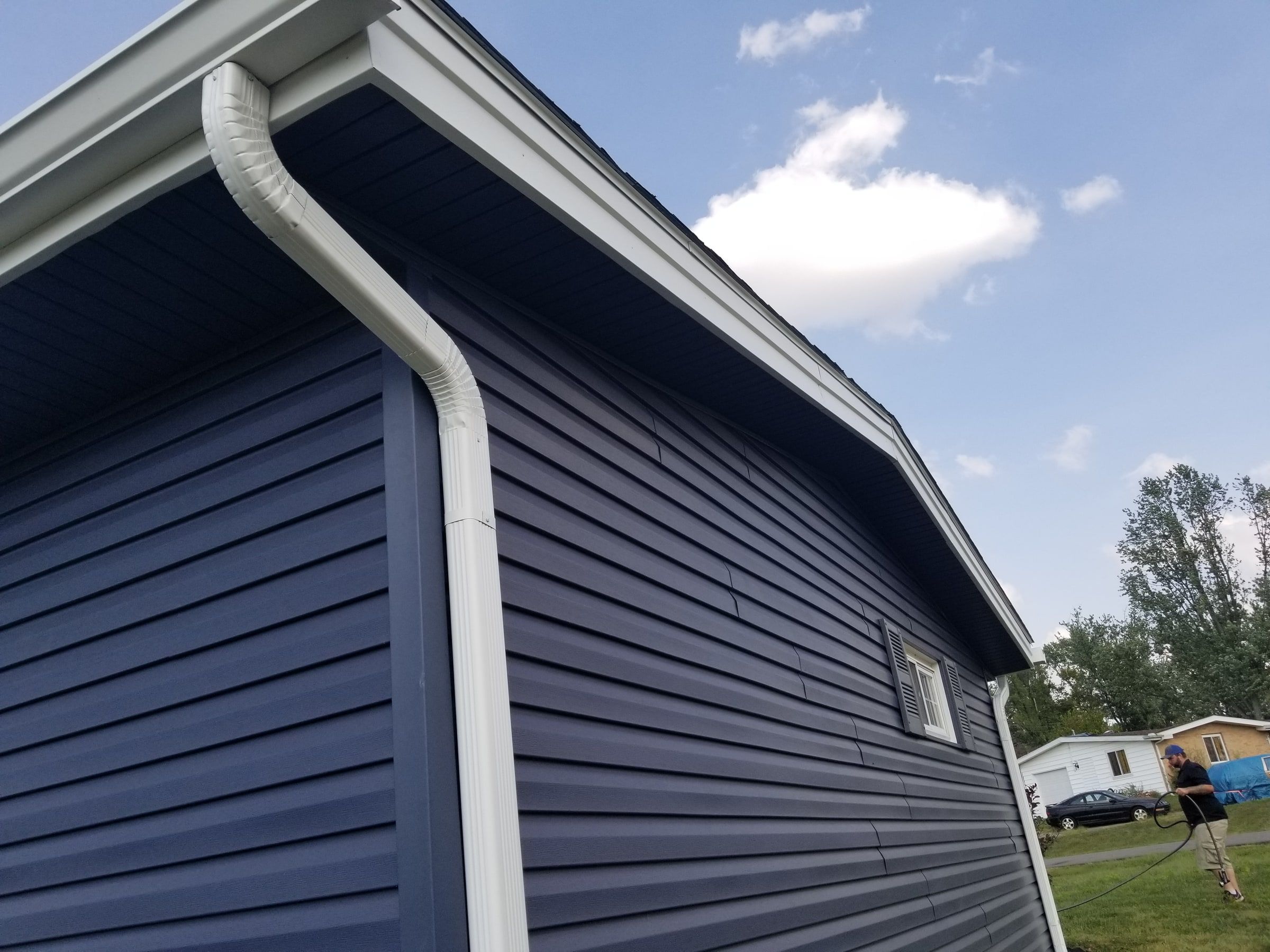 A white downspout at the corner of the new blue siding, Beavercreek, Ohio.