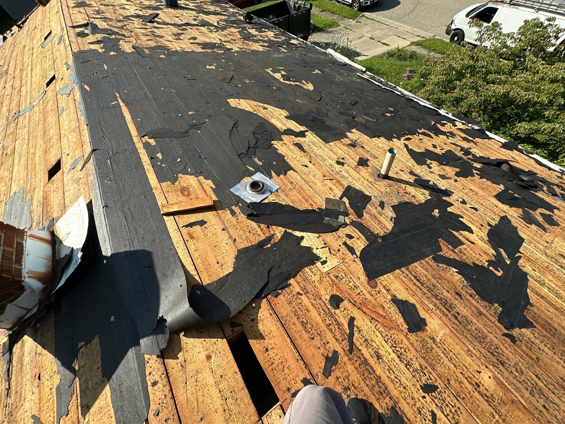 Old shingles and paper stripped back to the board deck around a plumbing pipe, Fairborn, Ohio.